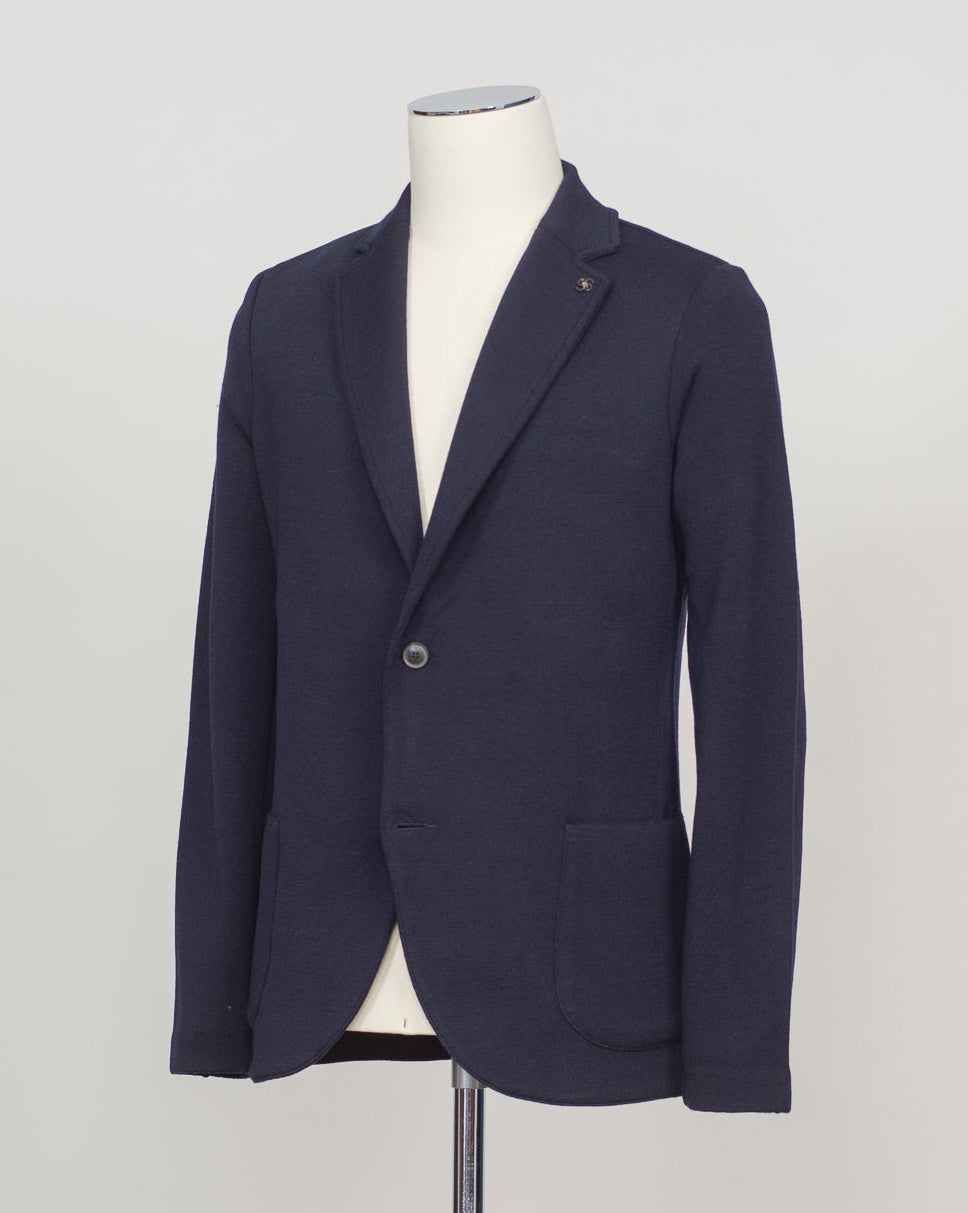 Refined elegance in pure merino. Gran Sasso's knitted blazer in navy delivers structured sophistication without formality—a foundation piece that transitions seamlessly from office to evening. Engineered for layering and designed to last. Gran Sasso Knitted Blazer / Navy Rain wool