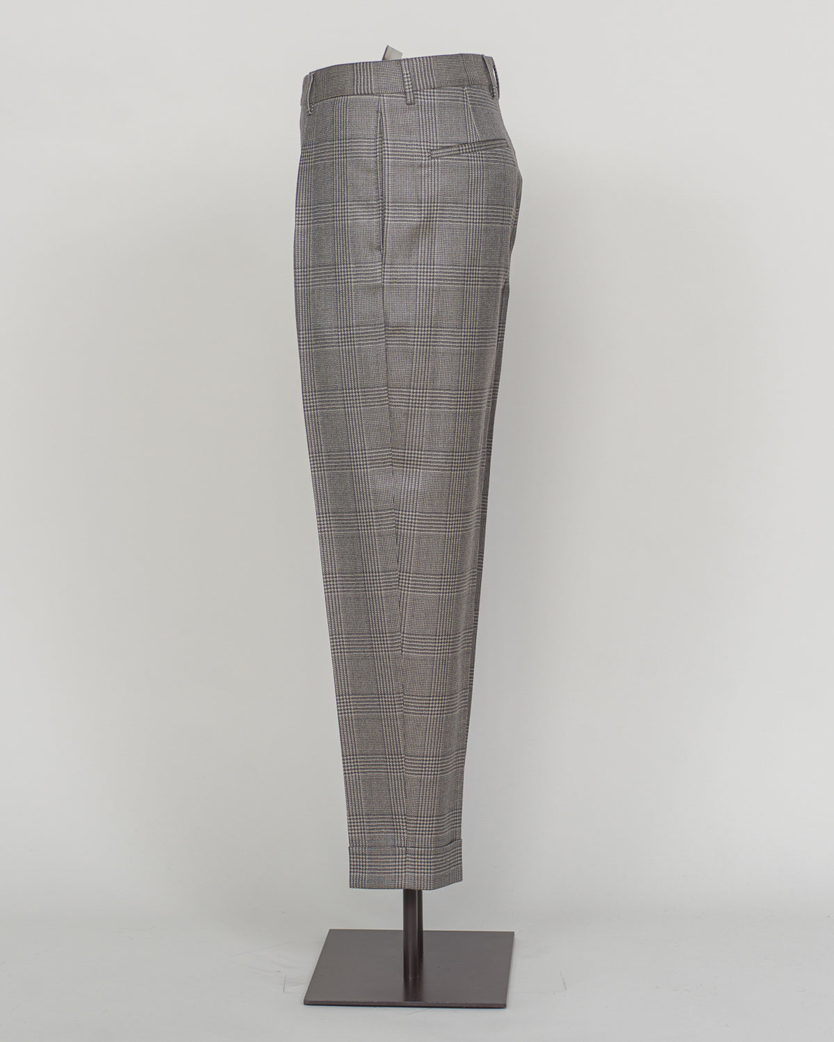 Berwich's Chiaia trousers showcase Italian tailoring heritage with a refined long glencheck pattern in warm greige. Cut with a contemporary silhouette and finished with precision pleating, these trousers balance classic structure with modern sophistication. The carefully selected fabric drapes with quiet elegance, making them an essential foundation for curated menswear wardrobes that demand both substance and understated style.
