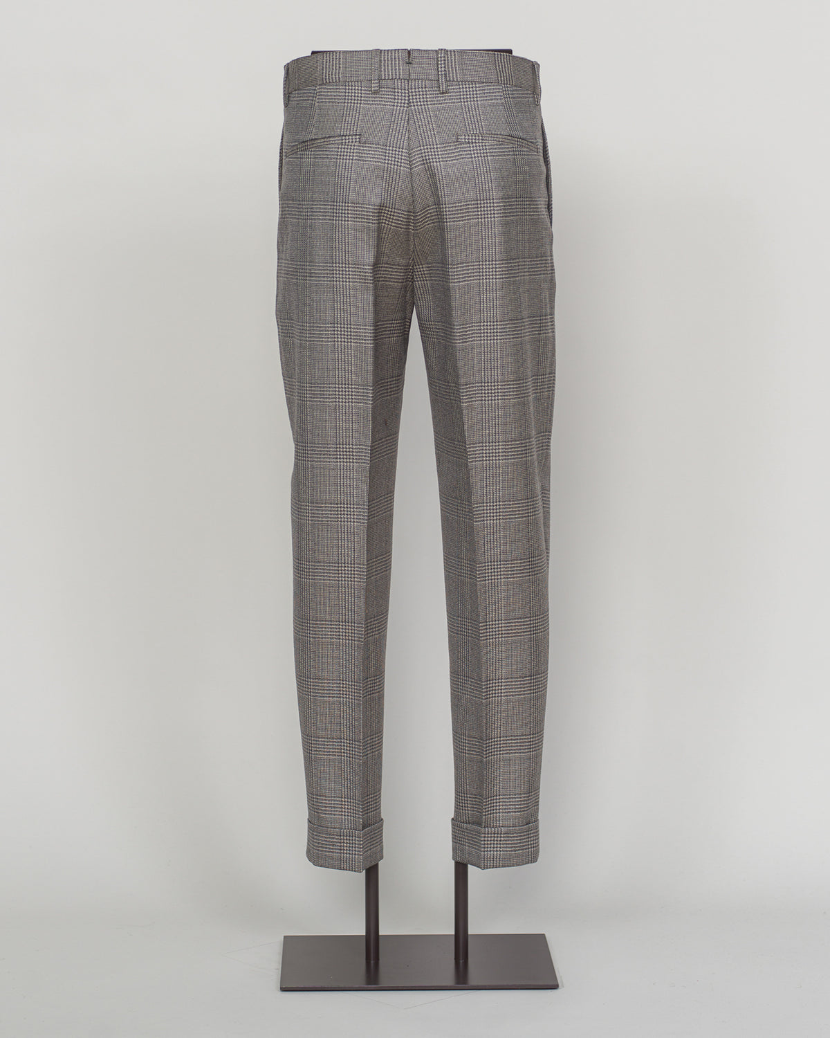 Berwich's Chiaia trousers showcase Italian tailoring heritage with a refined long glencheck pattern in warm greige. Cut with a contemporary silhouette and finished with precision pleating, these trousers balance classic structure with modern sophistication. The carefully selected fabric drapes with quiet elegance, making them an essential foundation for curated menswear wardrobes that demand both substance and understated style.