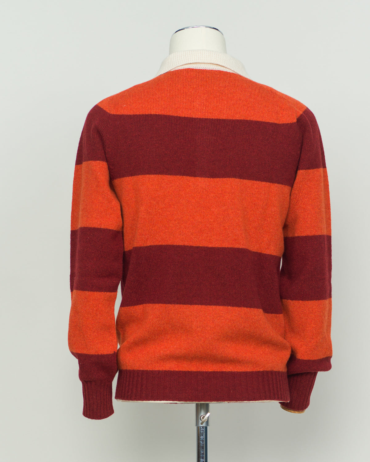 A timeless rugby polo crafted from pure wool, featuring Harley of Scotland's signature striped pattern in warm orange and red tones. The structured knit delivers excellent breathability and natural temperature regulation, ideal for layering or standalone wear. Classic collar and button placket with a relaxed yet refined fit that suits both casual and smart-casual settings. A versatile staple for the discerning wardrobe.