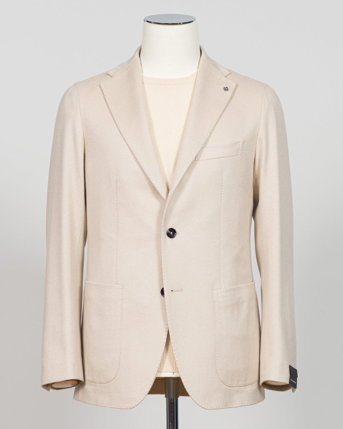 Luxurious cashmere sport jacket by Tagliatore in a refined light beige. Crafted from premium pure cashmere for exceptional softness and warmth. Tailored silhouette with classic styling that transitions seamlessly from business to casual occasions. An investment piece perfect for layering or wearing standalone. Ideal for those seeking timeless Italian craftsmanship and understated elegance. Tagliatore Cashmere Jacket / Light Beige