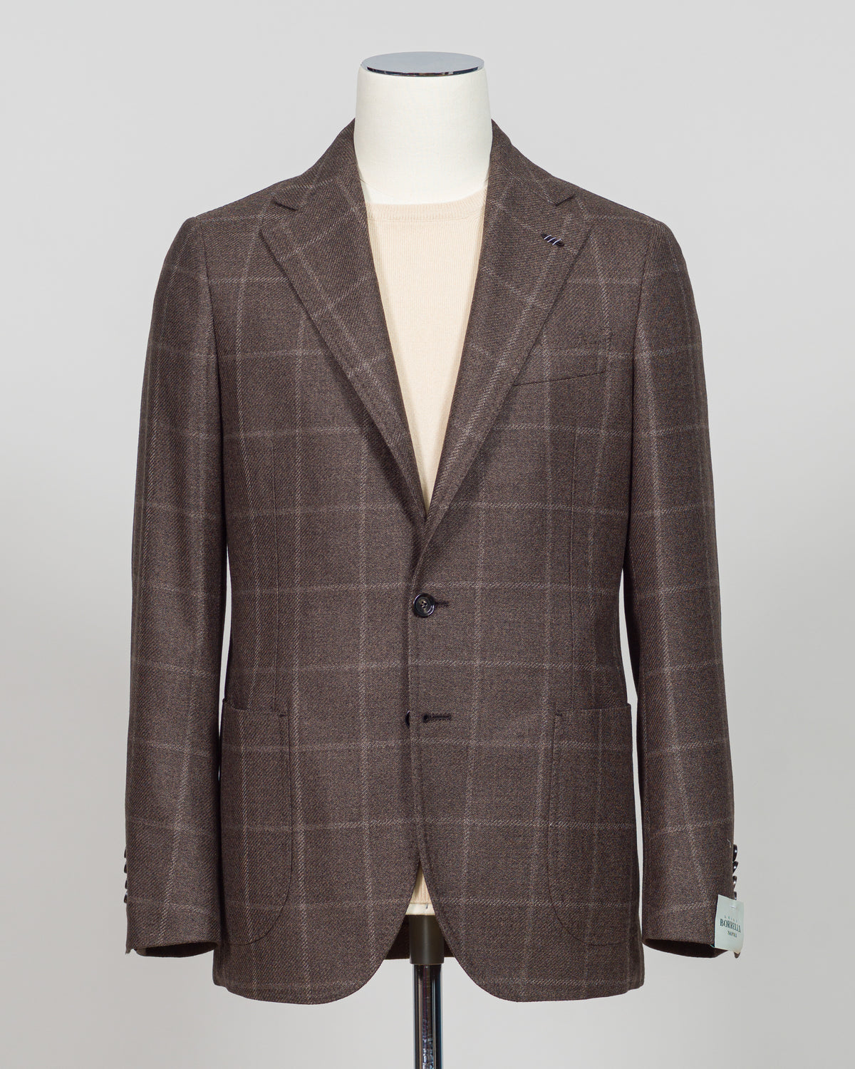 Crafted in Naples by Luigi Borrelli, this windowpane sport jacket exemplifies Italian tailoring precision. The structured brown pattern delivers versatile sophistication—pair it with charcoal trousers for boardroom presence or lighter separates for weekend elegance. Classic cut accommodates layering while maintaining a refined silhouette. A cornerstone piece for discerning menswear collections.