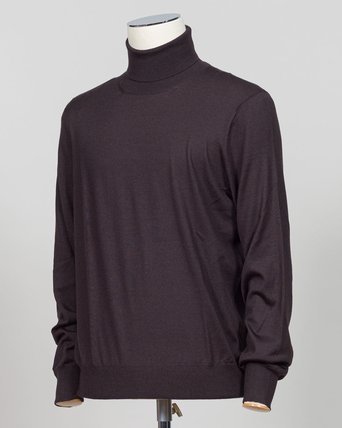 Luxurious roll neck in a refined blend of wool, cashmere and silk. The dark brown hue pairs effortlessly with tailored trousers and formal wear. Gran Sasso's Italian craftsmanship ensures a sumptuous drape and enduring comfort. A timeless layering essential for the discerning wardrobe. Gran Sasso Wool Cashmere & Silk Roll Neck / Dark Brown