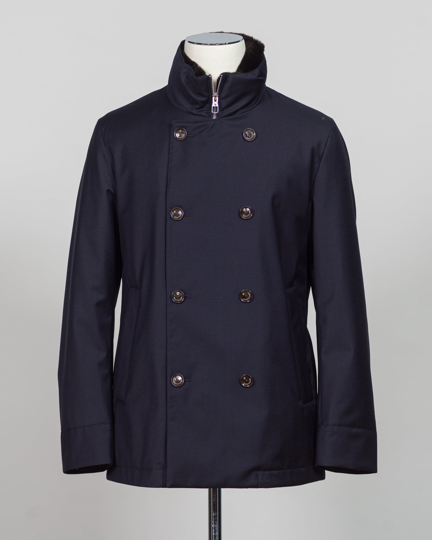 Montecore's double-breasted down jacket combines Italian tailoring precision with practical outerwear design. Navy wool outer with premium down filling delivers warmth without bulk, while structured shoulders and clean lines reflect luxury menswear craftsmanship. Horn buttons and internal quilting detail elevate everyday wear.
Perfect for layering across seasons—wear over knitwear or dress shirts. The relaxed yet refined silhouette suits both smart-casual and dressier occasions. Wind and water-resistant fi