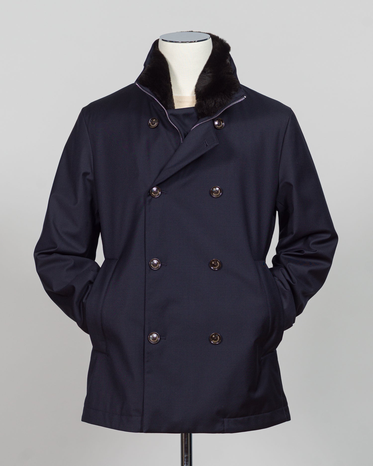 Montecore's double-breasted down jacket combines Italian tailoring precision with practical outerwear design. Navy wool outer with premium down filling delivers warmth without bulk, while structured shoulders and clean lines reflect luxury menswear craftsmanship. Horn buttons and internal quilting detail elevate everyday wear.
Perfect for layering across seasons—wear over knitwear or dress shirts. The relaxed yet refined silhouette suits both smart-casual and dressier occasions. Wind and water-resistant fi