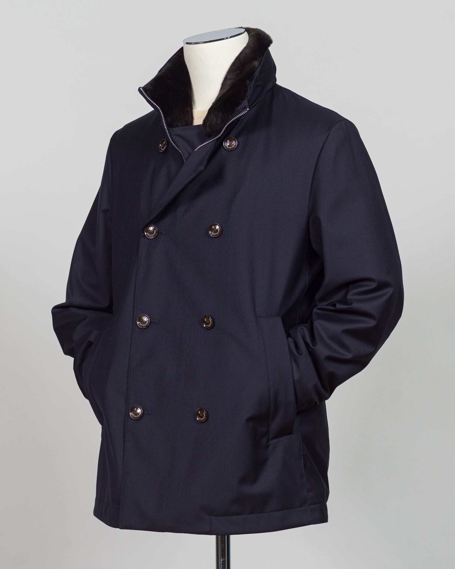 Montecore's double-breasted down jacket combines Italian tailoring precision with practical outerwear design. Navy wool outer with premium down filling delivers warmth without bulk, while structured shoulders and clean lines reflect luxury menswear craftsmanship. Horn buttons and internal quilting detail elevate everyday wear.
Perfect for layering across seasons—wear over knitwear or dress shirts. The relaxed yet refined silhouette suits both smart-casual and dressier occasions. Wind and water-resistant fi