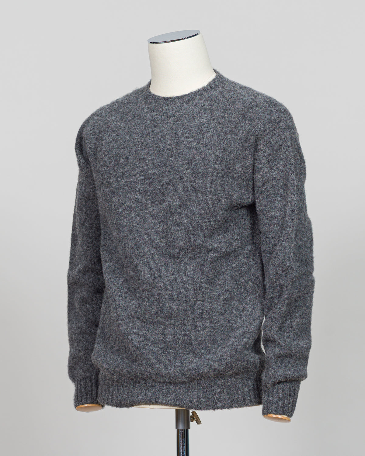 Harley of Scotland's iconic shaggy crew neck sweater in basalt. Hand-knitted using traditional Scottish techniques, this piece features a distinctive textured surface that catches light beautifully while delivering exceptional softness against the skin. The relaxed crew neck silhouette works seamlessly as a standalone layer or under tailored blazers for refined versatility.
Premium wool construction provides natural warmth and breathability across seasons. The generous shag pile creates visual depth and ta