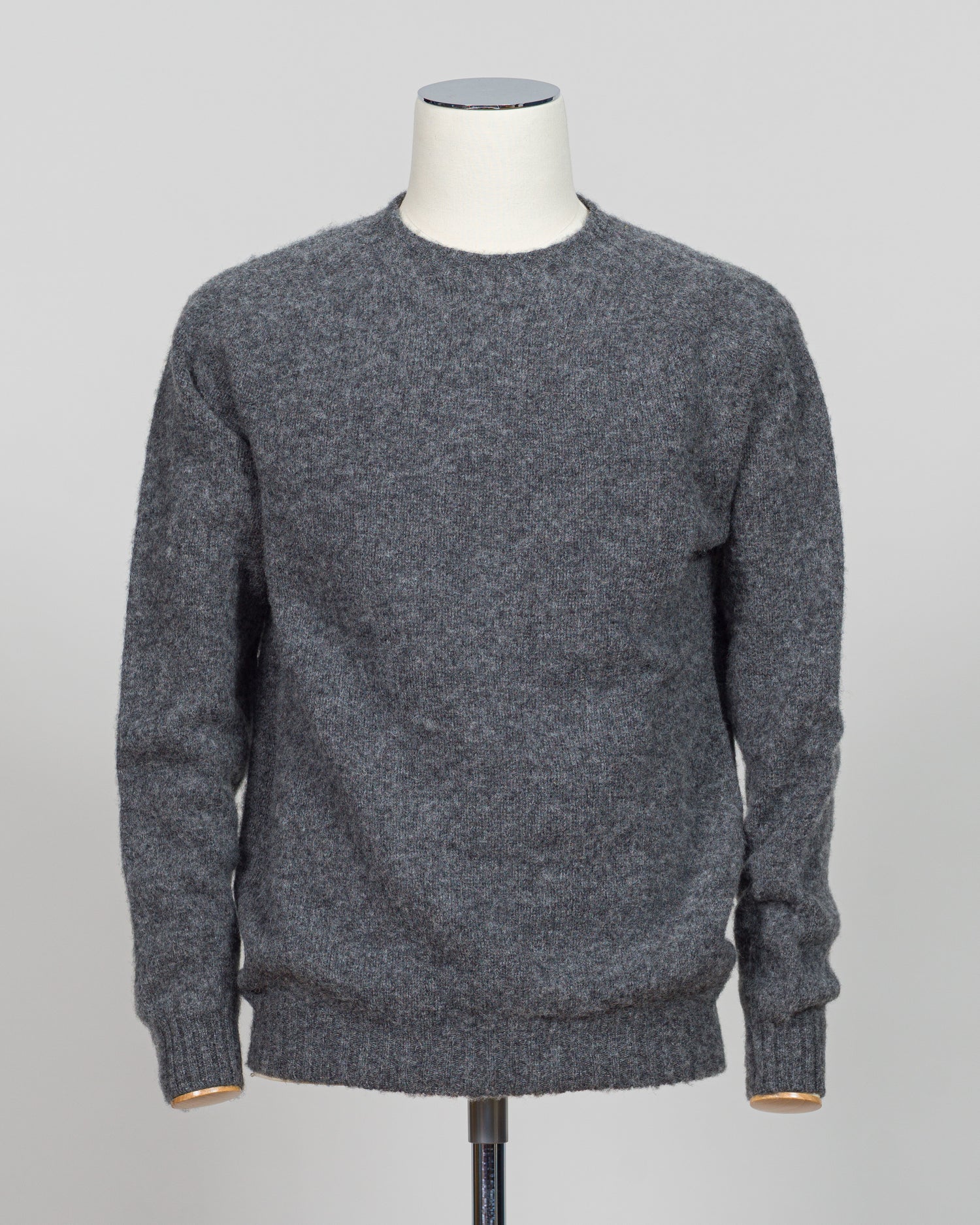 Harley of Scotland's iconic shaggy crew neck sweater in basalt. Hand-knitted using traditional Scottish techniques, this piece features a distinctive textured surface that catches light beautifully while delivering exceptional softness against the skin. The relaxed crew neck silhouette works seamlessly as a standalone layer or under tailored blazers for refined versatility.
Premium wool construction provides natural warmth and breathability across seasons. The generous shag pile creates visual depth and ta