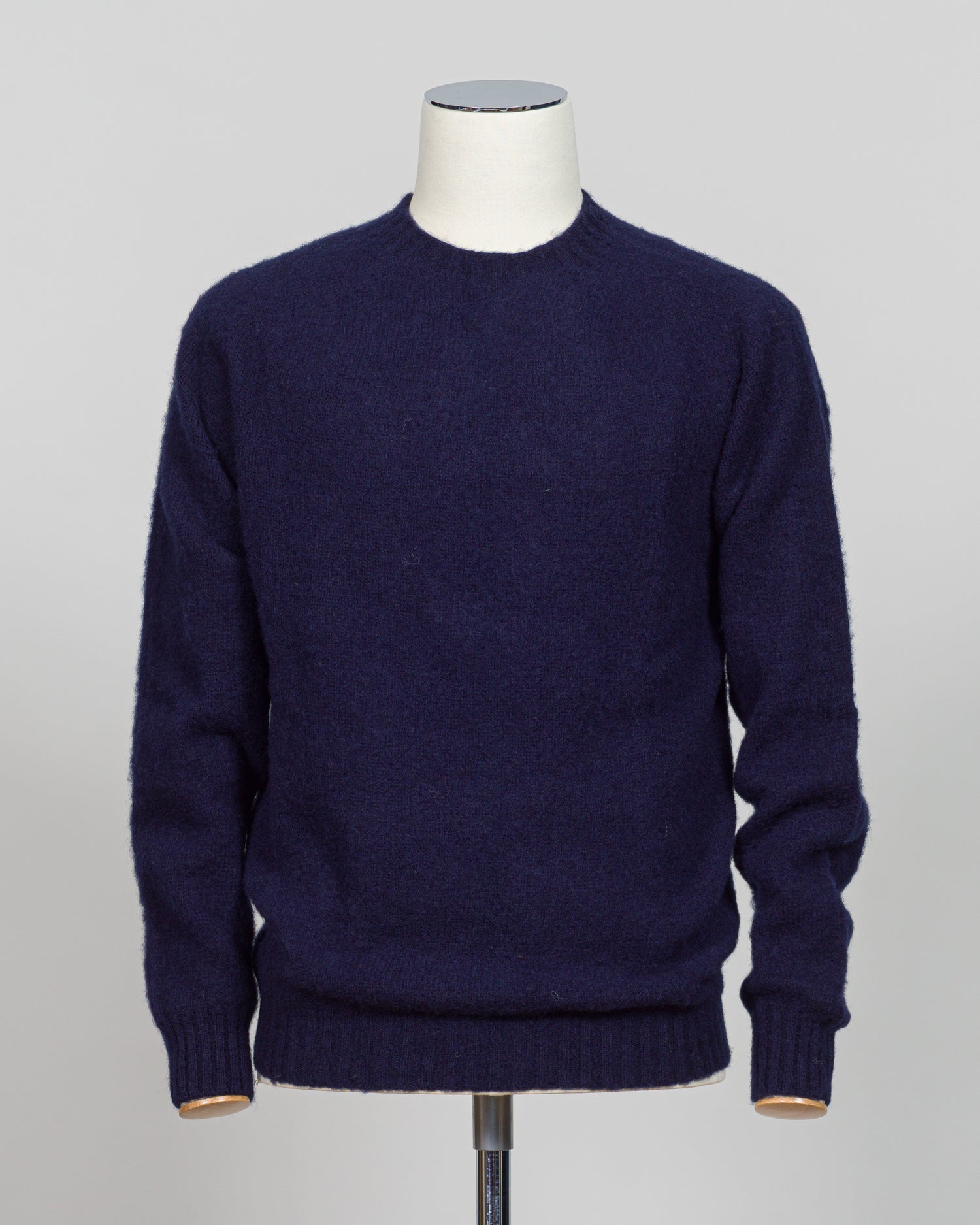 Harley of Scotland's iconic shaggy crew neck sweater in navy. Hand-knitted using traditional Scottish techniques, this piece features a distinctive textured surface that catches light beautifully while delivering exceptional softness against the skin. The relaxed crew neck silhouette works seamlessly as a standalone layer or under tailored blazers for refined versatility.
Premium wool construction provides natural warmth and breathability across seasons. The generous shag pile creates visual depth and tact