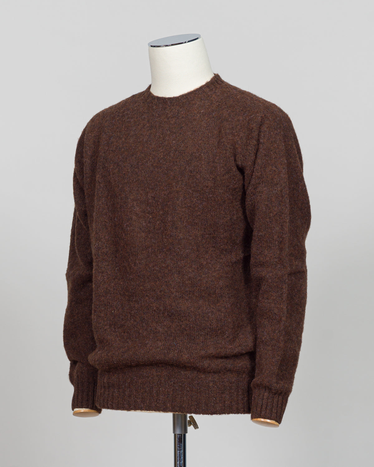 Harley of Scotland's iconic shaggy crew neck sweater in marron. Hand-knitted using traditional Scottish techniques, this piece features a distinctive textured surface that catches light beautifully while delivering exceptional softness against the skin. The relaxed crew neck silhouette works seamlessly as a standalone layer or under tailored blazers for refined versatility.
Premium wool construction provides natural warmth and breathability across seasons. The generous shag pile creates visual depth and ta