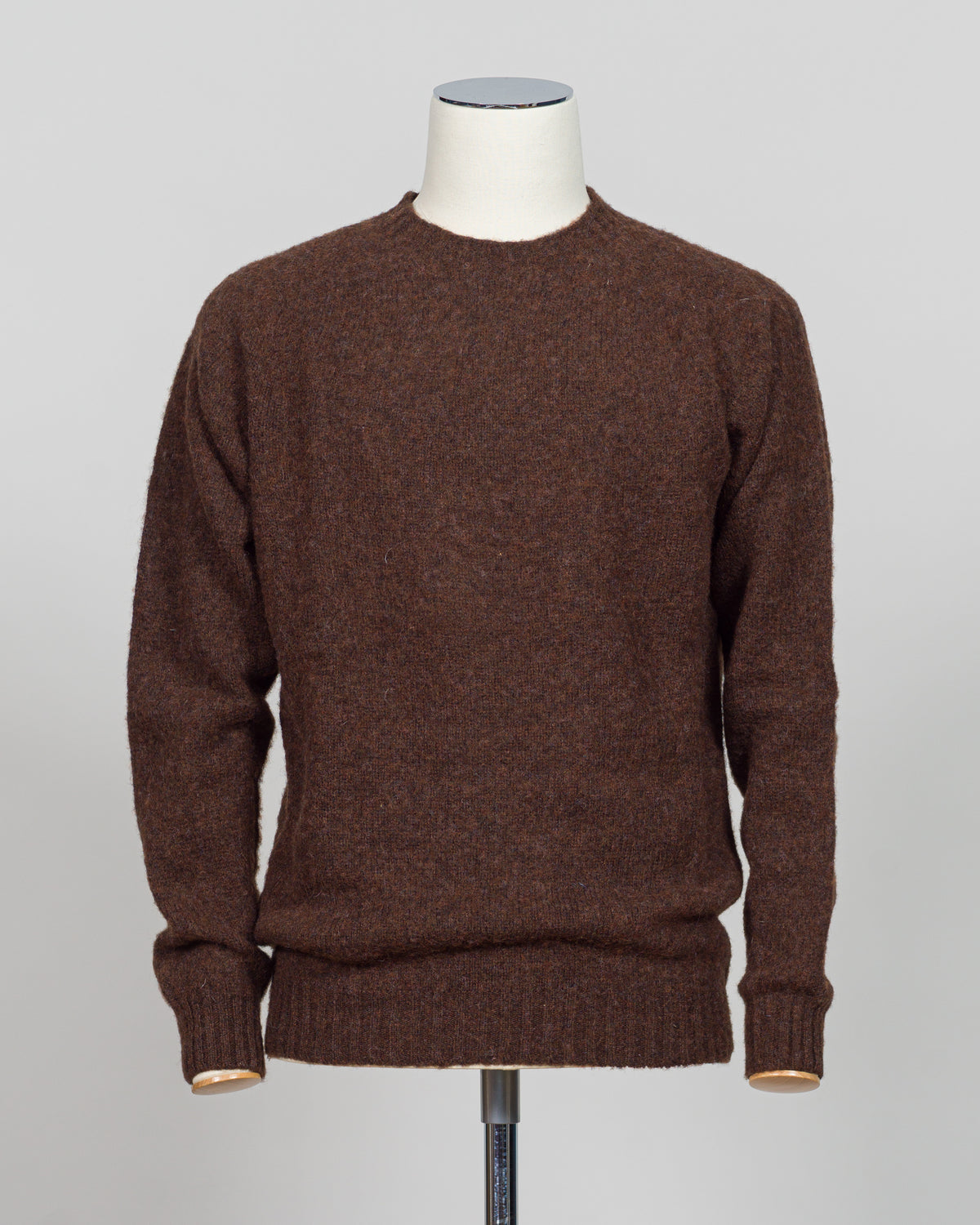 Harley of Scotland's iconic shaggy crew neck sweater in marron. Hand-knitted using traditional Scottish techniques, this piece features a distinctive textured surface that catches light beautifully while delivering exceptional softness against the skin. The relaxed crew neck silhouette works seamlessly as a standalone layer or under tailored blazers for refined versatility.
Premium wool construction provides natural warmth and breathability across seasons. The generous shag pile creates visual depth and ta
