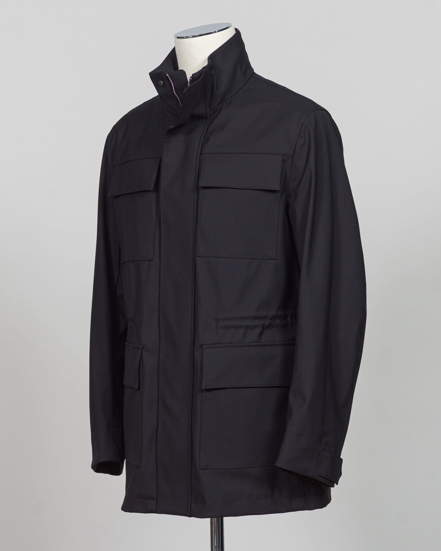 A black utility jacket with a high stand-up collar, displayed on a mannequin torso against a neutral gray background.