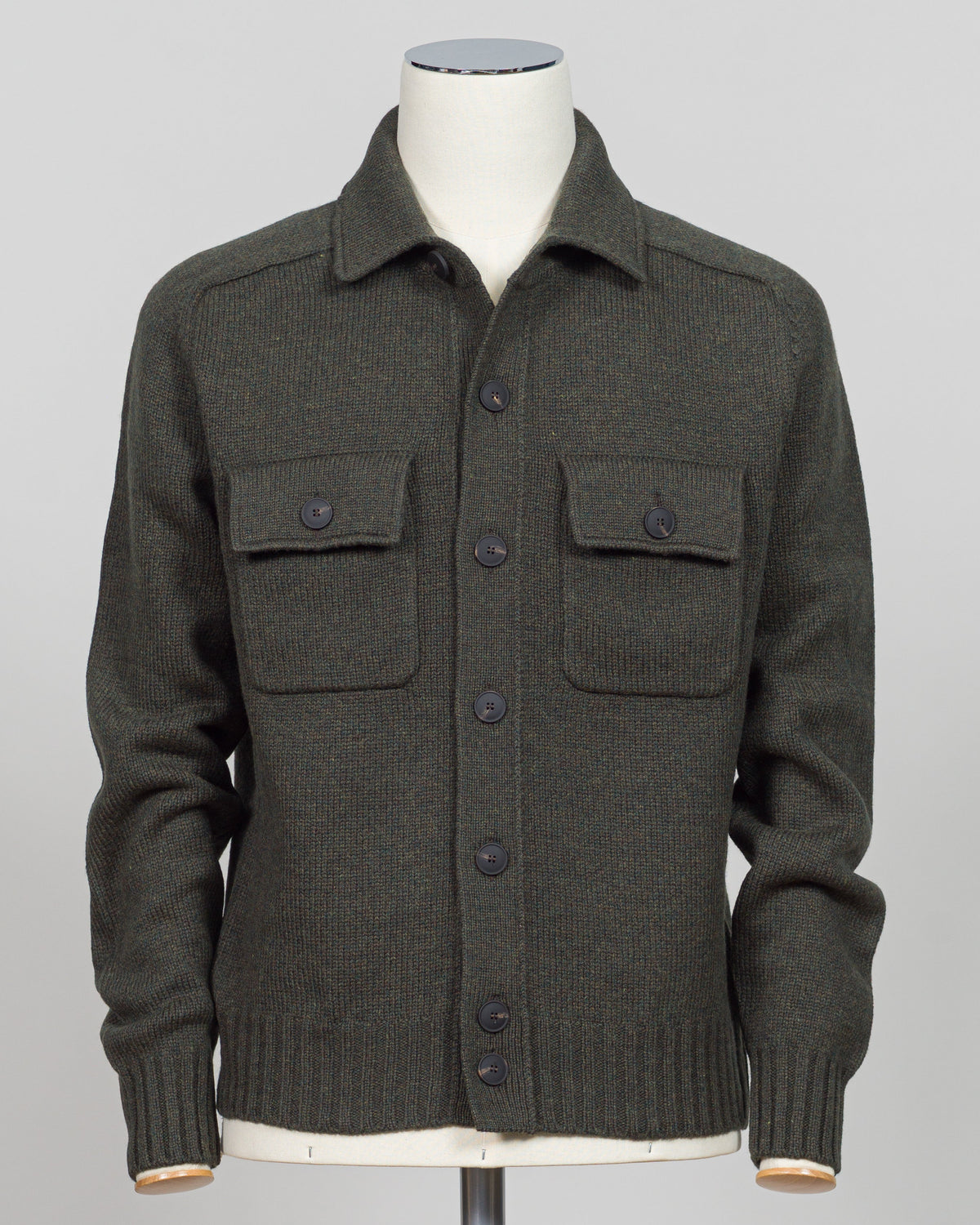 A dark green knit button-up cardigan sweater displayed on a white mannequin torso against a light gray background.