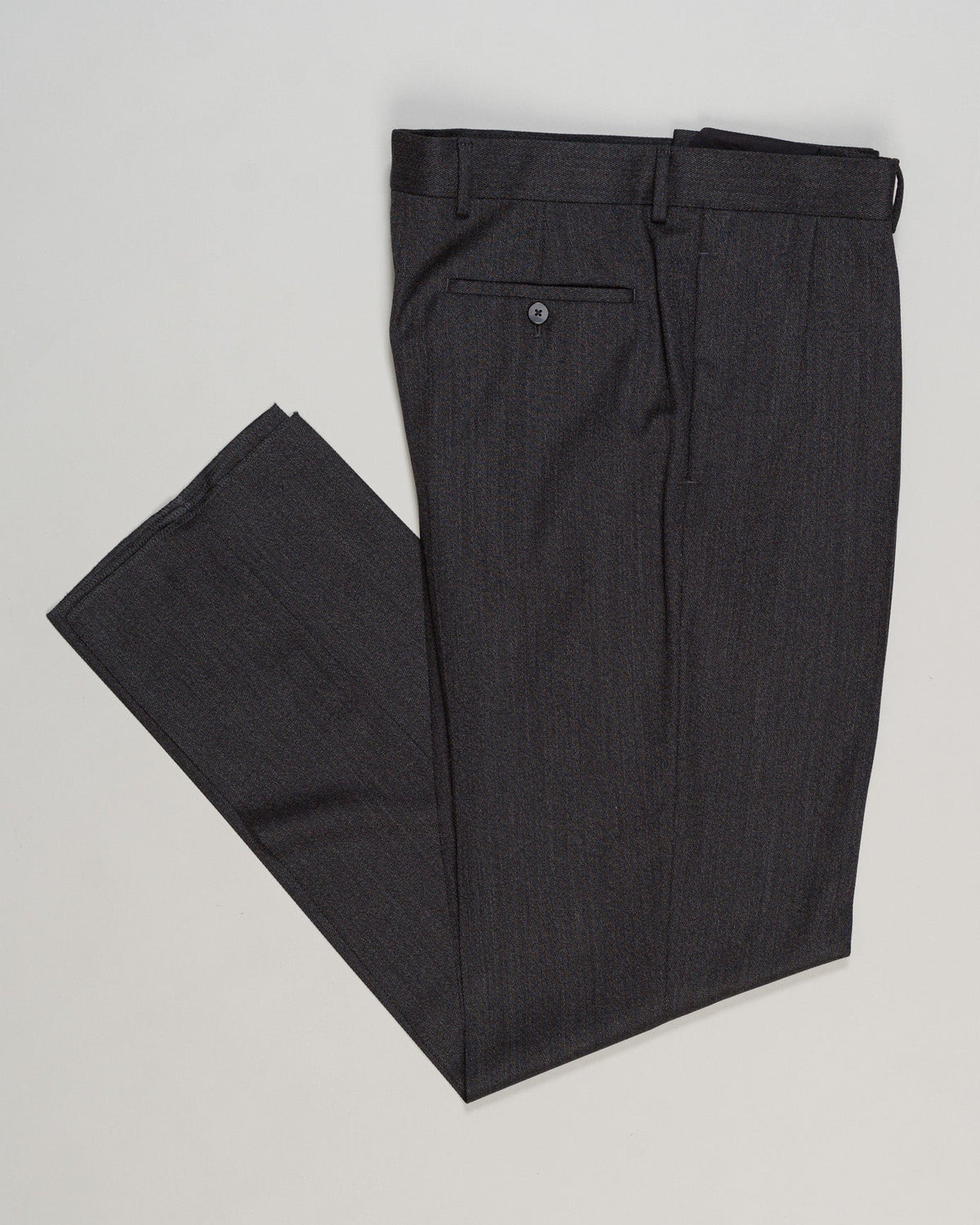 Tailored Caruso trousers in a refined covert weave, featuring elegant knife pleats that define the silhouette. Dark grey wool offers versatile sophistication for both formal occasions and elevated everyday wear. The structured construction and precise tailoring ensure a graceful drape and enduring quality characteristic of Italian craftsmanship. Caruso Pleated Covert Wool Trousers / Dark Grey
