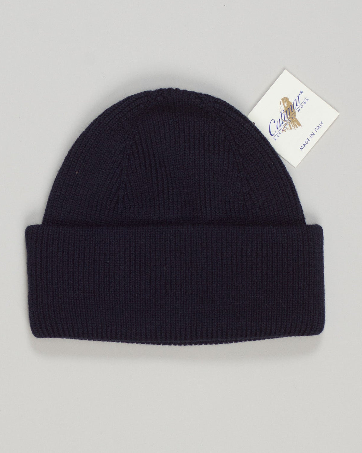 A refined wool watch cap in deep navy, crafted for understated elegance and everyday warmth. The Calimar combines Italian knitwear tradition with a timeless silhouette—structured yet relaxed, versatile enough for casual layering or as a standalone statement piece. Premium wool construction ensures durability and natural temperature regulation. An essential addition to any curated menswear wardrobe. Calimar Wool Watch Cap / Navy