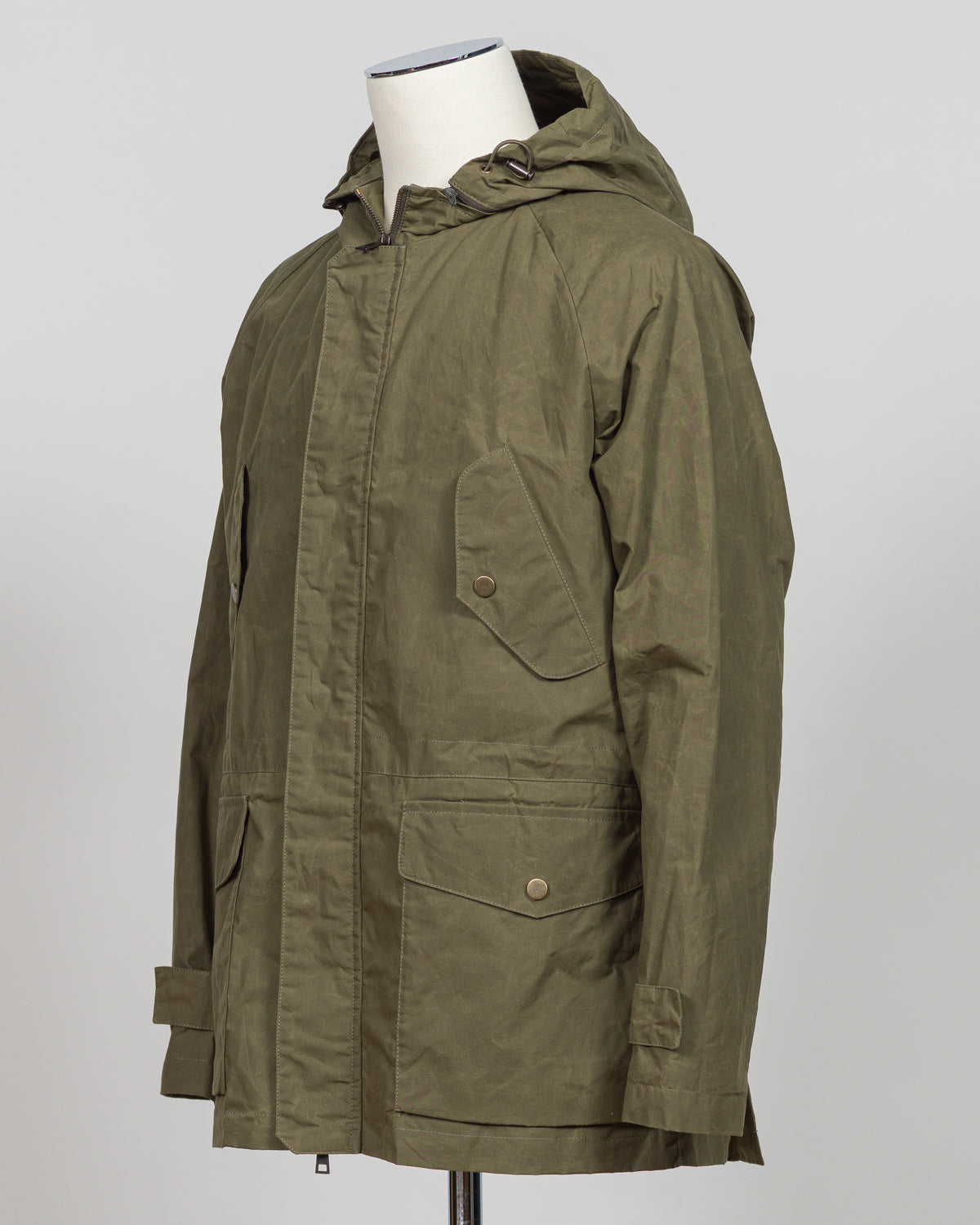 A timeless waxed cotton short parka built for versatile layering and unpredictable weather. The water-resistant finish and structured silhouette offer refined protection without bulk, while the compact length ensures easy movement and pairs seamlessly with tailored pieces. Durable construction and a refined aesthetic make it a wardrobe essential for the discerning gentleman.