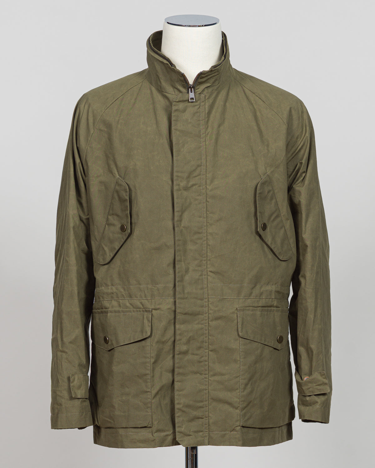 A timeless waxed cotton short parka built for versatile layering and unpredictable weather. The water-resistant finish and structured silhouette offer refined protection without bulk, while the compact length ensures easy movement and pairs seamlessly with tailored pieces. Durable construction and a refined aesthetic make it a wardrobe essential for the discerning gentleman.