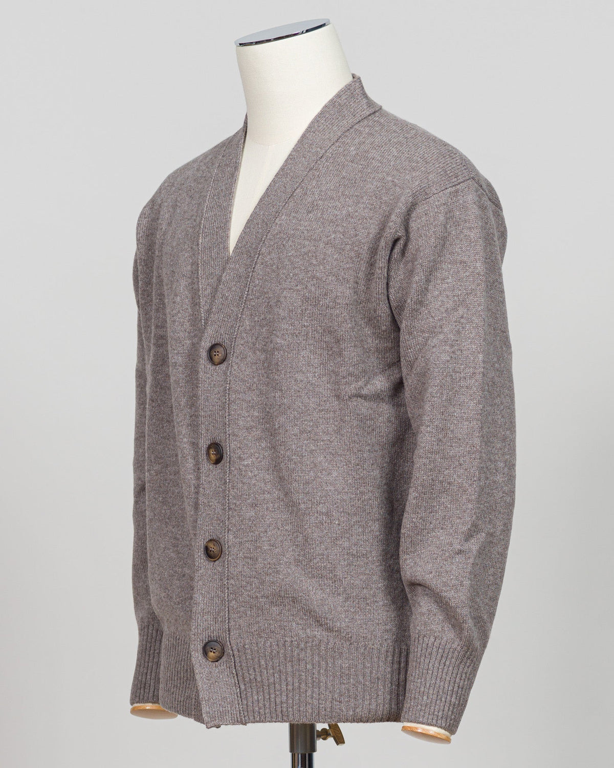 A heather gray knit cardigan sweater displayed on a white mannequin torso against a light gray studio background. Gran Sasso's timeless cashmere crew neck in soft beige epitomizes understated luxury. Crafted from 100% pure cashmere with a vintage-washed finish that develops character with wear, this Italian-made essential features a relaxed fashion fit, ribbed detailing at the hem and cuffs, and a refined crew neckline. An investment piece that anchors any wardrobe. Gran Sasso Cashmere Crew Neck / Beige