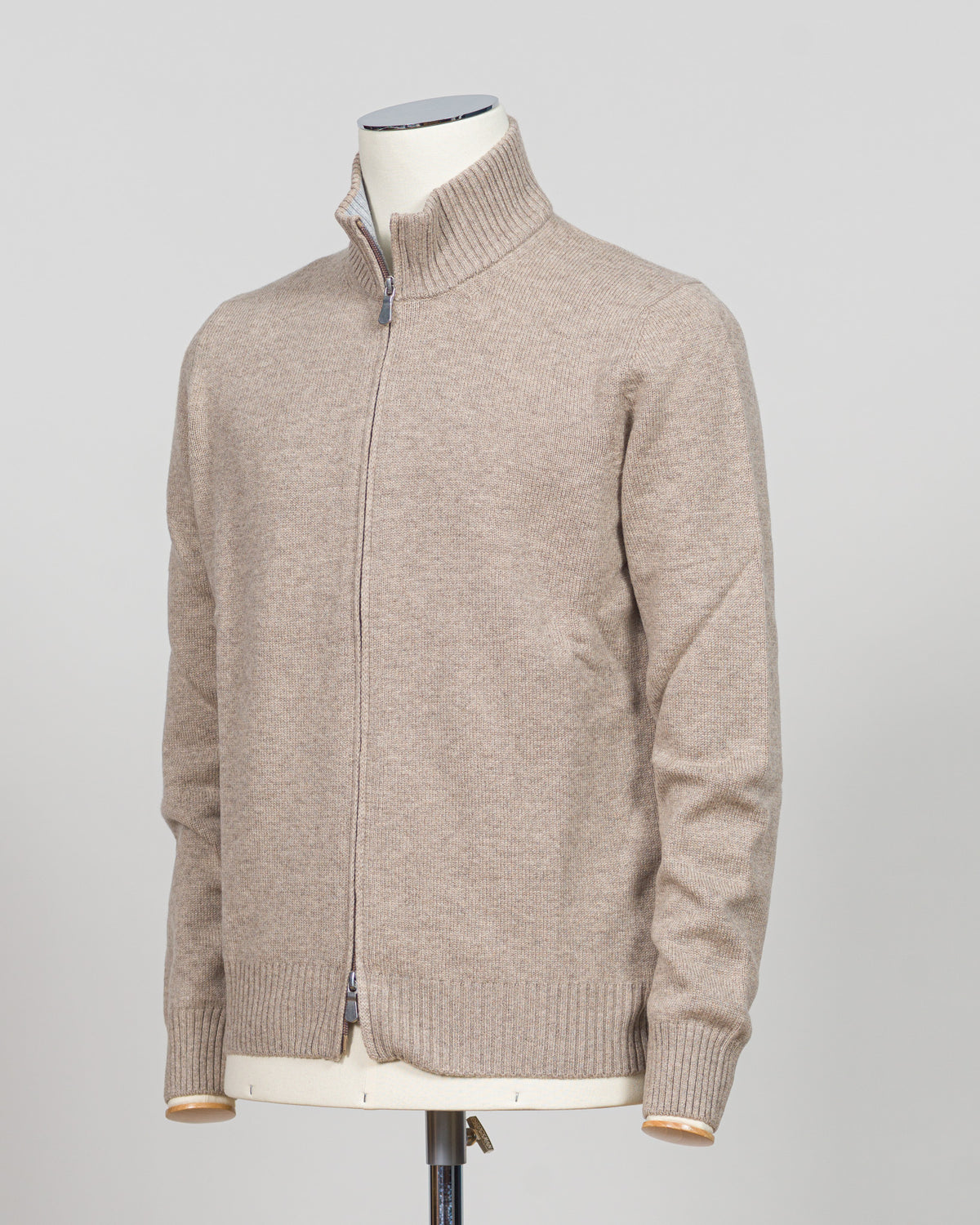 Crafted from sumptuous merino wool, this full-zip knit from Gran Sasso delivers effortless elegance in a versatile light beige. The refined construction offers a contemporary silhouette with timeless appeal, perfect for layering or wearing alone. A wardrobe essential that transitions seamlessly from casual to refined settings. Gran Sasso Full-Zip Knit / Light Beige