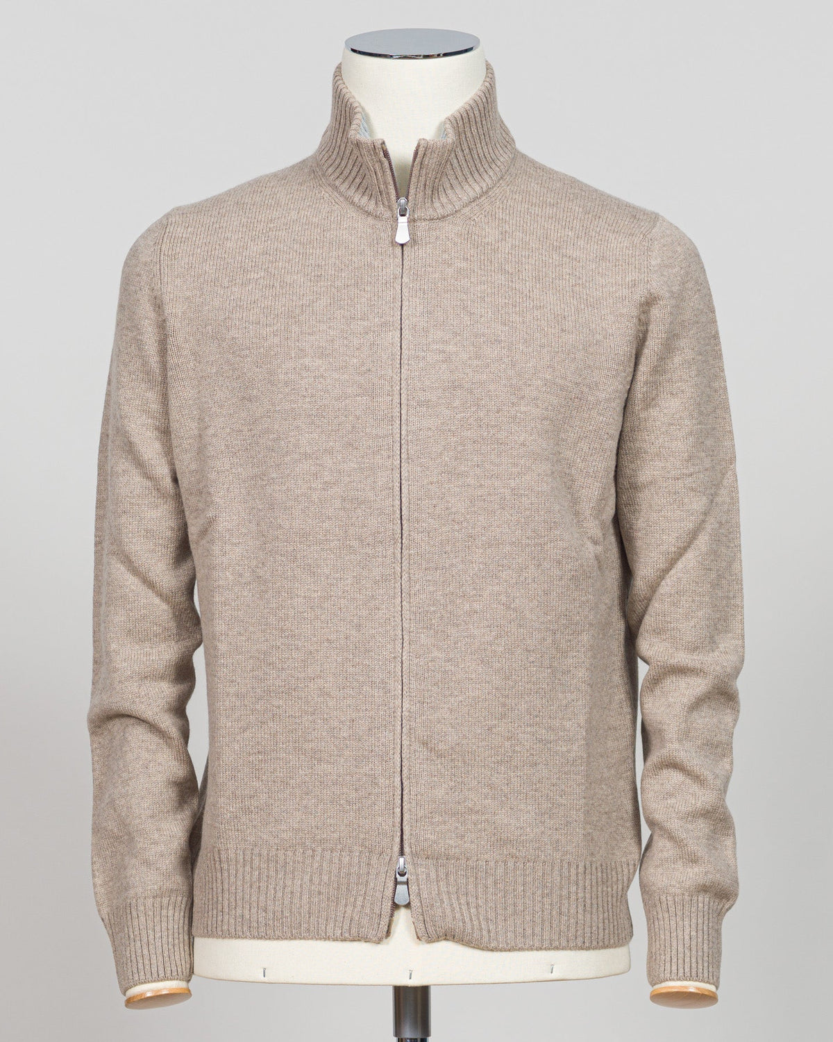 Crafted from sumptuous merino wool, this full-zip knit from Gran Sasso delivers effortless elegance in a versatile light beige. The refined construction offers a contemporary silhouette with timeless appeal, perfect for layering or wearing alone. A wardrobe essential that transitions seamlessly from casual to refined settings. Gran Sasso Full-Zip Knit / Light Beige