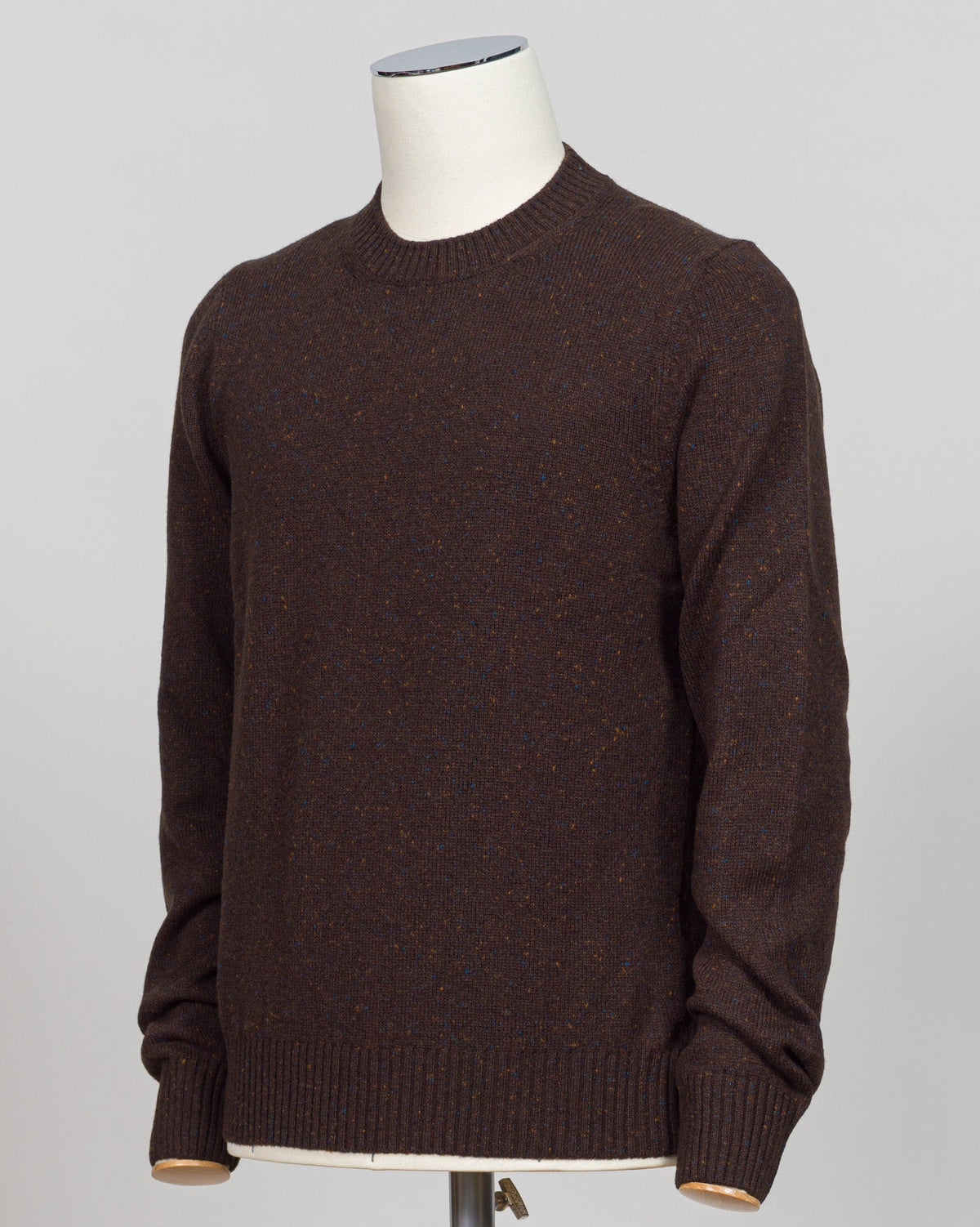 The Donegal effect is a classic textural hallmark of Irish knitwear, created by weaving small flecks of contrasting fiber throughout the yarn. This distinctive pattern adds visual depth and movement to the fabric, giving it character and authentic craftsmanship appeal. The subtle speckled texture catches light beautifully while remaining understated—a refined detail that elevates the piece beyond plain knit. Donegal construction is traditionally associated with premium wool blends and demands careful yarn s
