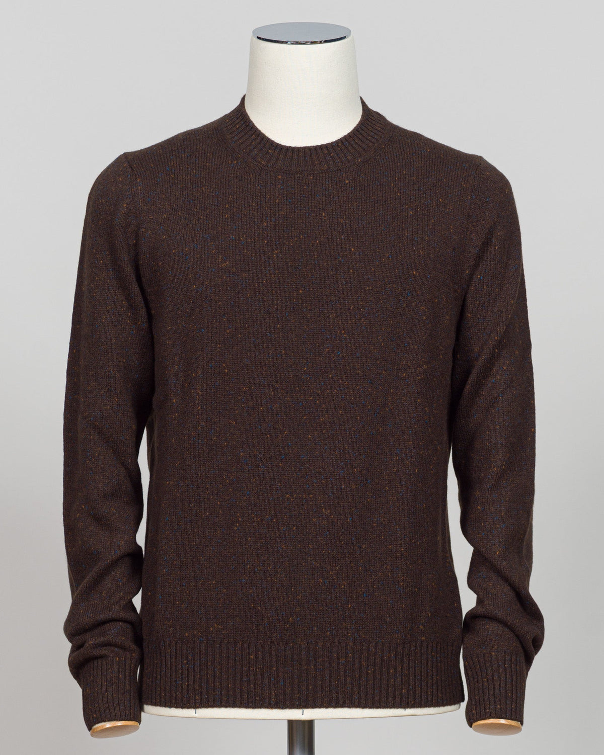 The Donegal effect is a classic textural hallmark of Irish knitwear, created by weaving small flecks of contrasting fiber throughout the yarn. This distinctive pattern adds visual depth and movement to the fabric, giving it character and authentic craftsmanship appeal. The subtle speckled texture catches light beautifully while remaining understated—a refined detail that elevates the piece beyond plain knit. Donegal construction is traditionally associated with premium wool blends and demands careful yarn s