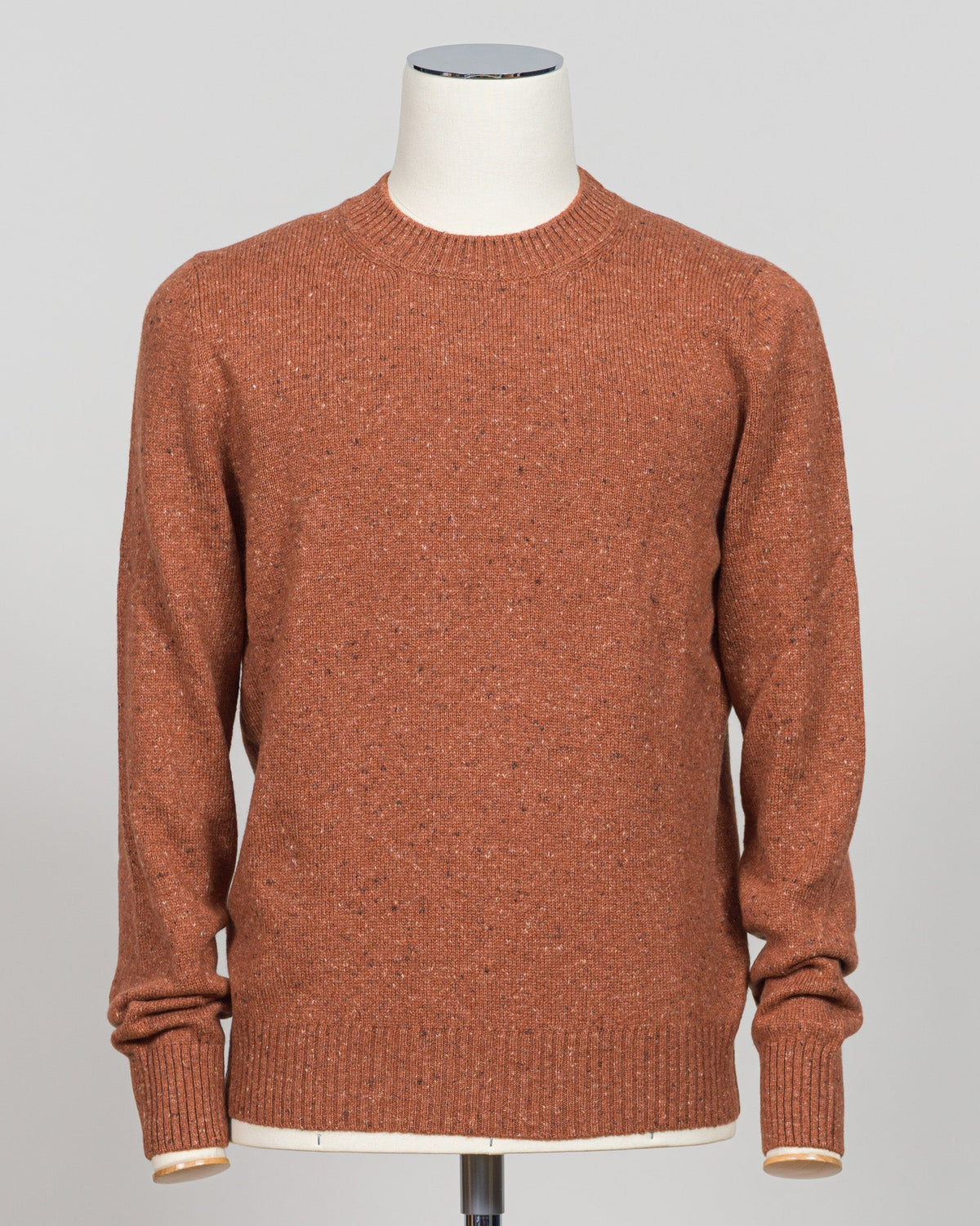 Italian wool knitwear in a warm orange donegal wool. Donegal tweed features a distinctive texture with flecks of contrasting fiber woven throughout, creating visual depth and a tactile, artisanal appearance. Crew neck construction offers versatile layering for classic tailoring. Refined texture and weight suit both structured suiting and casual wear. Premium craftsmanship from Gran Sasso, a heritage knitwear house. Gran Sasso Donegal Crew Neck / Orange