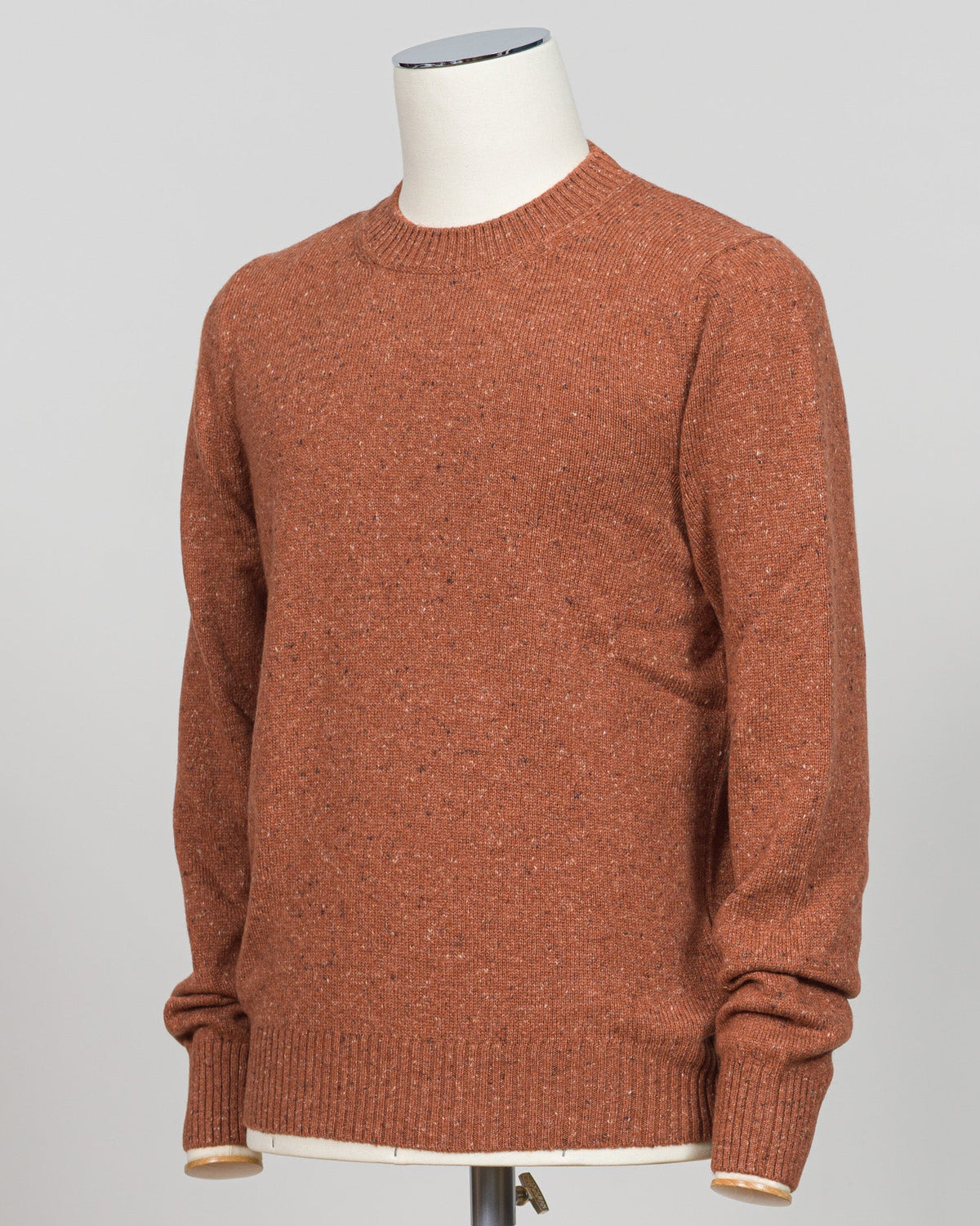 Italian wool knitwear in a warm orange donegal wool. Donegal tweed features a distinctive texture with flecks of contrasting fiber woven throughout, creating visual depth and a tactile, artisanal appearance. Crew neck construction offers versatile layering for classic tailoring. Refined texture and weight suit both structured suiting and casual wear. Premium craftsmanship from Gran Sasso, a heritage knitwear house. Gran Sasso Donegal Crew Neck / Orange