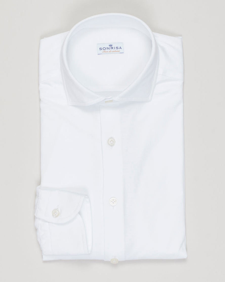 Timeless cotton jersey shirt in crisp white. Soft, breathable fabric with a relaxed fit perfect for layering or standalone wear. Italian craftsmanship meets everyday versatility—an essential for any refined wardrobe. Sonrisa Cotton Jersey Shirt / White