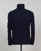 Gran Sasso cable knit roll neck made of special 3-ply Air Wool quality. The special feature of this garment is the yarn that holds microscopic air bubbles between the fibers, making it at the same time warm and light. Art. 13117/22622 Col. 598 Navy 100% Wool Made in Italy