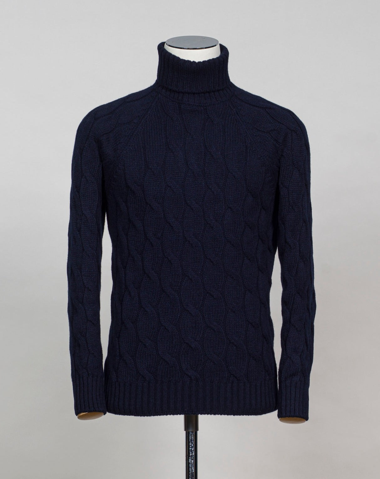 Gran Sasso cable knit roll neck made of special 3-ply Air Wool quality. The special feature of this garment is the yarn that holds microscopic air bubbles between the fibers, making it at the same time warm and light. Art. 13117/22622 Col. 598 Navy 100% Wool Made in Italy