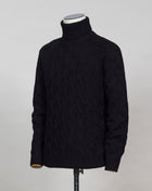 Gran Sasso cable knit roll neck made of special 3-ply Air Wool quality. The special feature of this garment is the yarn that holds microscopic air bubbles between the fibers, making it at the same time warm and light. Art. 13117/22622 Col. 099 Black 100% Wool Made in Italy