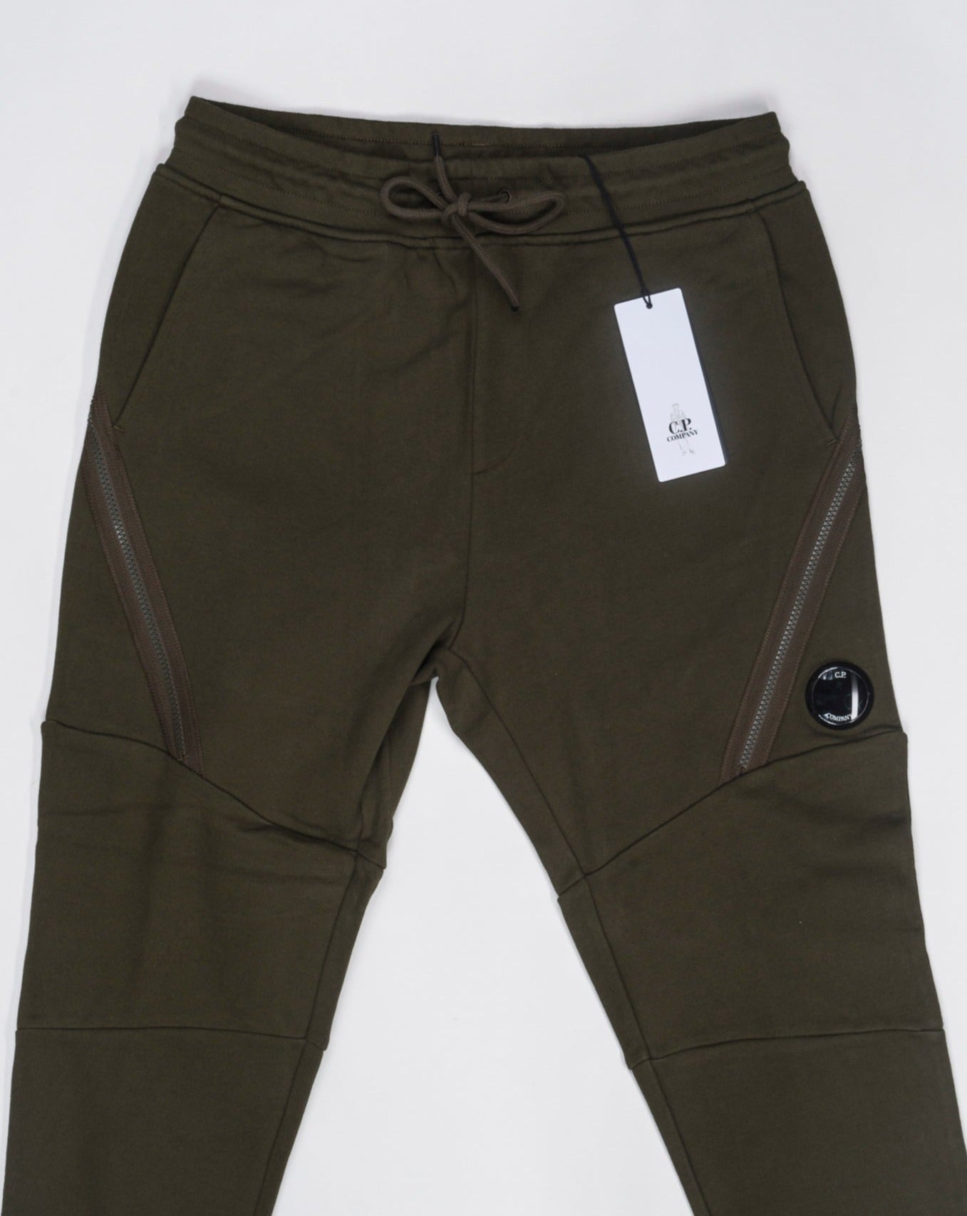Art. 15CMSP084A 005086W Col 683 Green 100% Cotton Adjustable drawstring waistband Slanted hand pockets Zipped side pockets Ribbed leg opening Lens detail C.P. Company Diagonal Raised Fleece Zipped Track Pants / Ivy Green