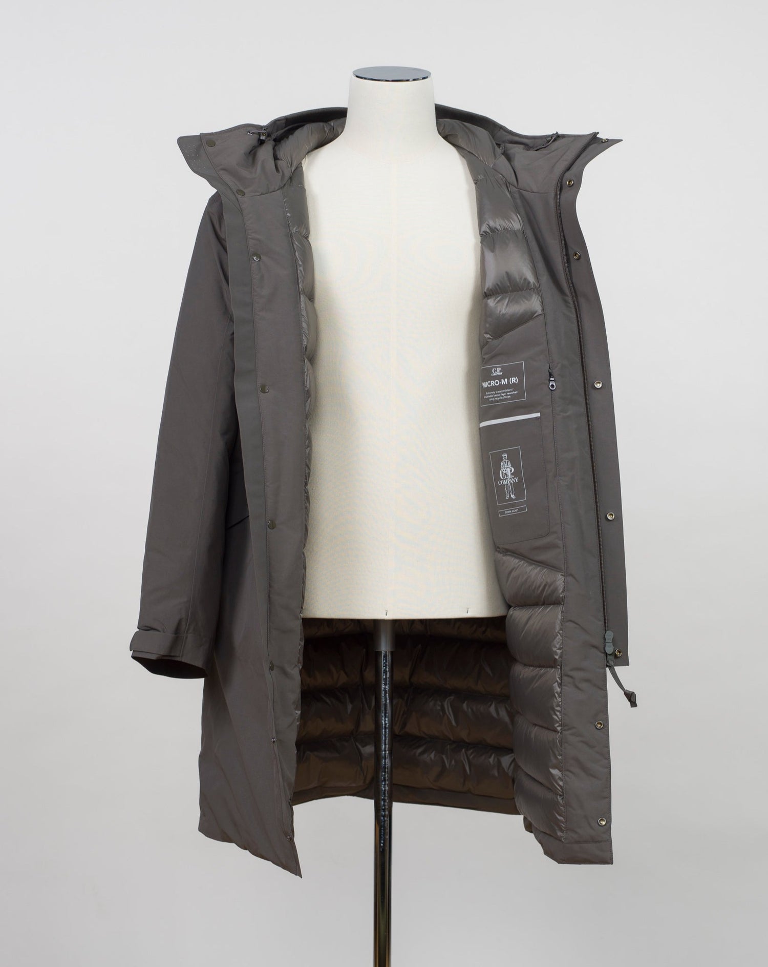Article: 15CMOW255A 006355A Color: 670 / Olive Night External fabric: 100% Polyester Lining: 100% Polyamide / Nylon Padding (Feather): 90% White duck down, 10% Feather Adjustable hood with logo detail Hidden button and zip fastening Breathable armpit ventilation Taped shoulder seams Storm flap Internal pocket Angular hand pockets Adjustable waist and cuffs Logo detail