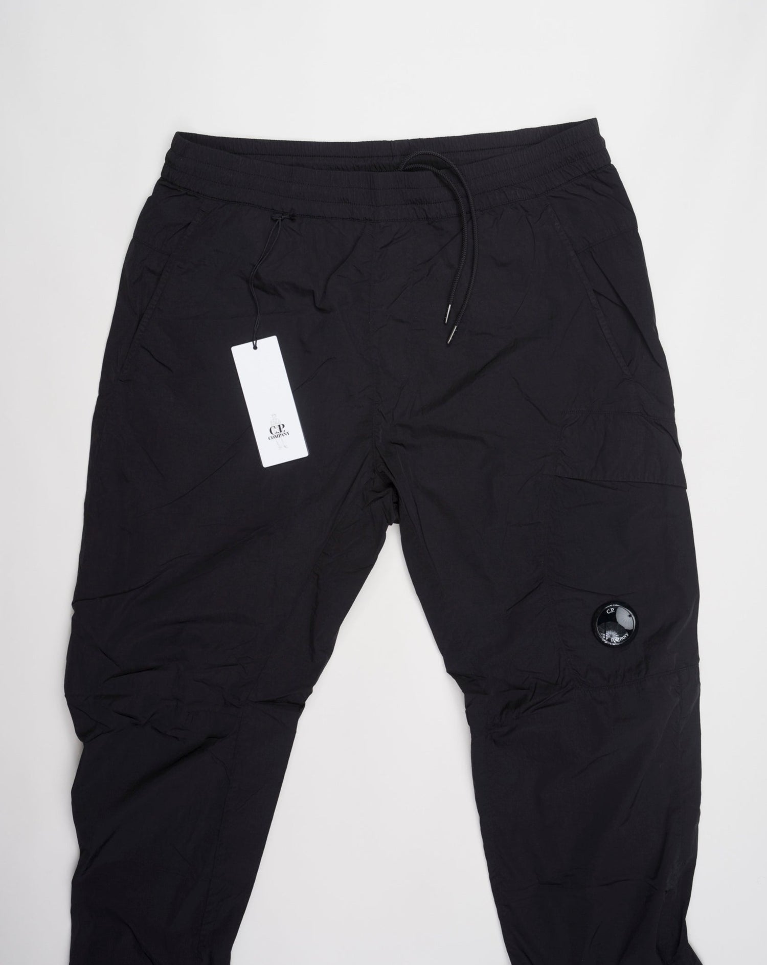 Multifilament fabric in Recycled nylon yarn Regular fit Drawstring waist Cuffed leg opening Single cargo pocket on left Leg Lens detail Garment dyed Article: 15CMPA247A005904G Color: Black / 999