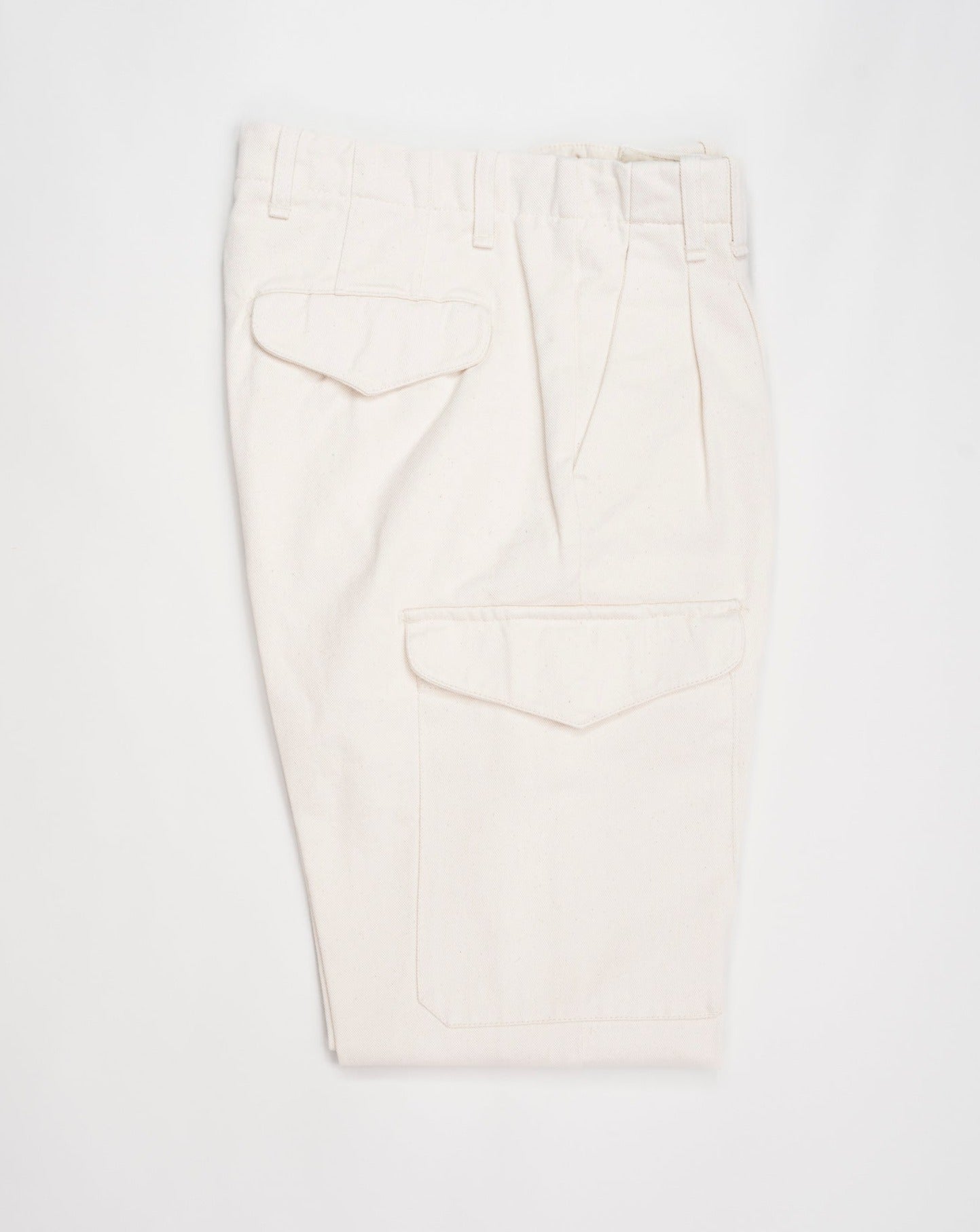 Article: 23WM45L Color: 04 / Natural White Composition: 100% Cotton Carrot fit Ajustable hem Cargo pocket on right side Pleated front Delivered in Myths cotton bag Made in Italy Myths Pleated Cargo Trousers / Natural White