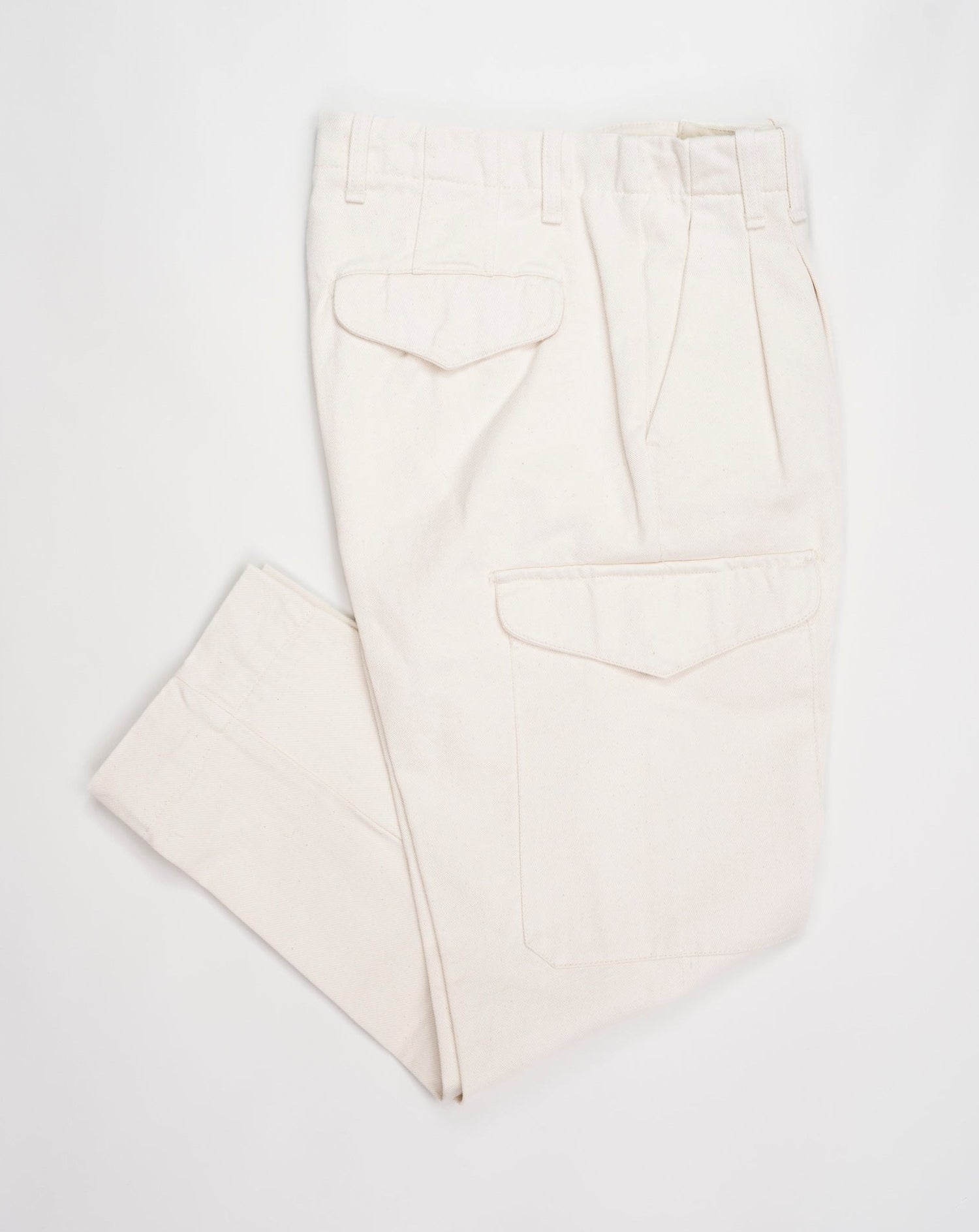 Article: 23WM45L Color: 04 / Natural White Composition: 100% Cotton Carrot fit Ajustable hem Cargo pocket on right side Pleated front Delivered in Myths cotton bag Made in Italy Myths Pleated Cargo Trousers / Natural White