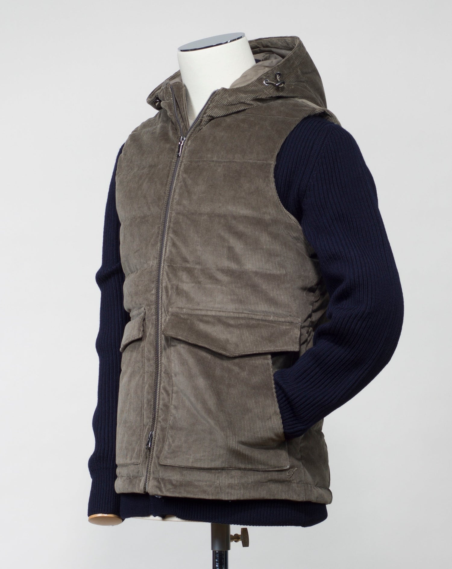 Fixed, adjustable hood Stenströms Corduroy Down Vest / Olive Two way zip in front 2 flapped pockets with snap fasteners in front 2 hand warming pocket 2 inside pockets Adjustable hem Article: 4300251995 Color: Olive / 370 Main fabric 98% cotton 2% spandex Filling 90% down 10% feather