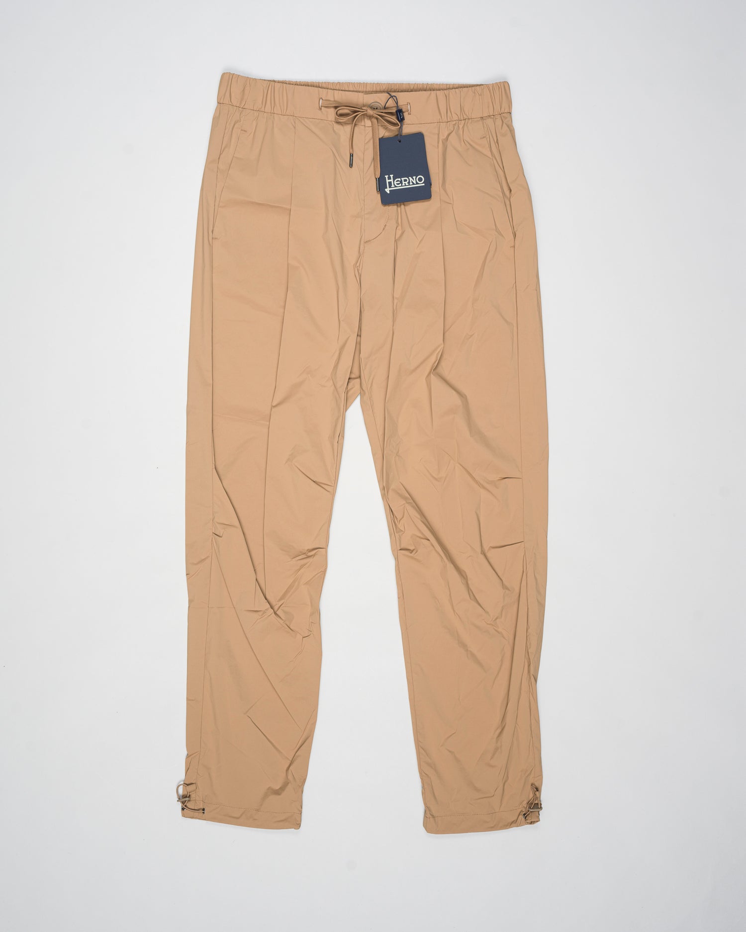 Trousers made of 20 denier stretch nylon whose weft and warp create a lightweight, matt and stretch fabric.
Comfortable to wear thanks to the drawstring that can be adapted to the desired fit, the style has a casual yet sophisticated feel that updates your everyday wardrobe.
Regular fit
Elastic with drawstring waist
Pleats at the front
Zip and button fastening
Slanted pockets
Patch pockets on the back
Drawstring at the ankles
Article: PT000041U 12431SZ
Color: Camel / 2157