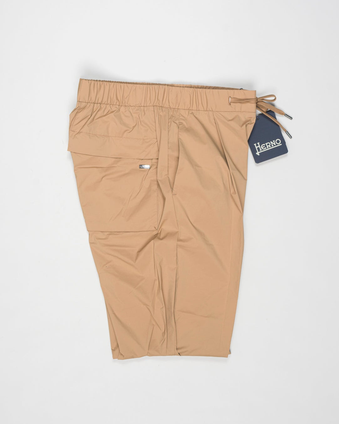 Trousers made of 20 denier stretch nylon whose weft and warp create a lightweight, matt and stretch fabric.
Comfortable to wear thanks to the drawstring that can be adapted to the desired fit, the style has a casual yet sophisticated feel that updates your everyday wardrobe.
Regular fit
Elastic with drawstring waist
Pleats at the front
Zip and button fastening
Slanted pockets
Patch pockets on the back
Drawstring at the ankles
Article: PT000041U 12431SZ
Color: Camel / 2157