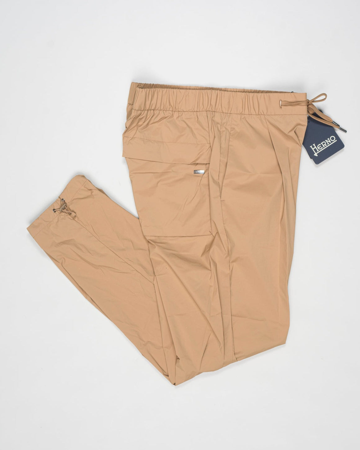 Trousers made of 20 denier stretch nylon whose weft and warp create a lightweight, matt and stretch fabric.
Comfortable to wear thanks to the drawstring that can be adapted to the desired fit, the style has a casual yet sophisticated feel that updates your everyday wardrobe.
Regular fit
Elastic with drawstring waist
Pleats at the front
Zip and button fastening
Slanted pockets
Patch pockets on the back
Drawstring at the ankles
Article: PT000041U 12431SZ
Color: Camel / 2157