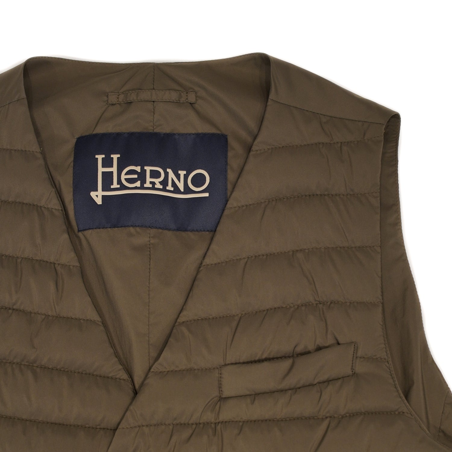 Herno In-Tech™ Alternative Down Waistcoat in Green. Great piece for layering.A true must have for every modern gentleman. Wear it under jacket or over a knit. Great for traveling as it packs small and weighs almost nothing. In-Tech™ Alternative Down Water Repellent Breathable Light Insulation 5 buttons 3 pockets Adjustable back External layer 100% Polyamide Internal padding 100% Polyester PC0039U 19288 7745 Made in Romania
