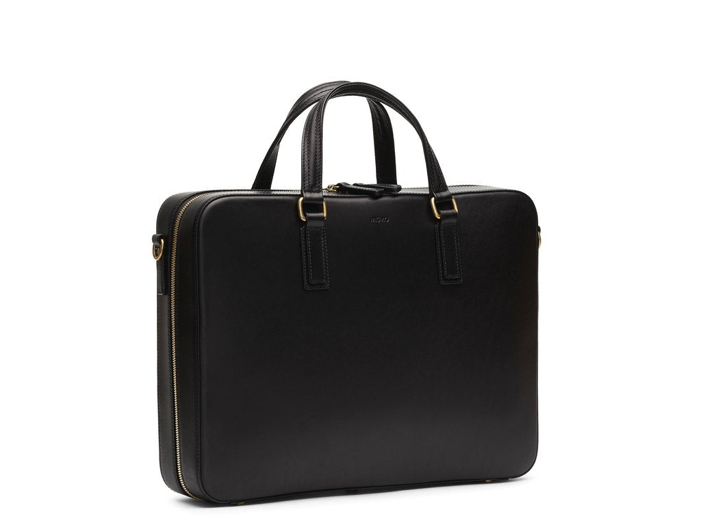 Measurements: L: 39 H: 29 W: 8,5cm Body: Vegetable tanned full-grain cow leather Leather trimmings: Vegetable tanned full-grain cow leather Hardware: Polished ZAMAK Hooks - Golden Lining: Cotton/nylon stripe lining - Off white/anthracite Zippers: Hand-polished YKK Excella Art. No. FG010118 briefcase in a design kept as clean as possible to allow the vegetable full-grain leather to really shine. Features a signature zipper opening that runs from bottom to bottom