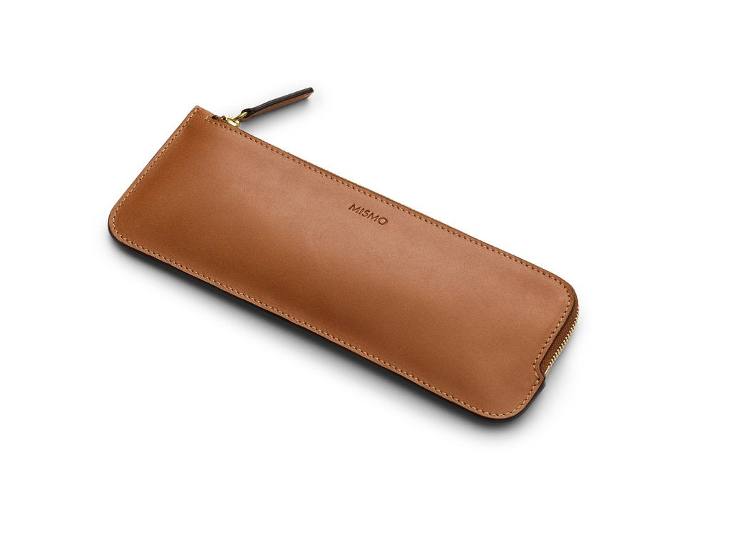 A sleek and elegant storage option for your pencils and small creative items. Useful for keeping your desk space neat and tidy, as well as for keeping your creative tools organized while on-the-go. Tuck this little pouch into your favoured travel or commuter bag to keep all of your writing utensils neatly assembled. Measurements: L: 22 H: 8,5 W: 0,5 (cm) Body: Vegetable tanned full-grain cow leather Leather trimmings: Vegetable tanned full-grain cow leather Lining: Cotton/nylon stripe lining in off white/a