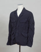 ed into a fibre fine enough to be used to weave Nycra. CP Blazer Nycra R MBZ250A00 5864G 888 Total Eclipse / Dark Blue 2 way zip + press studs in front 4 pockets in front with snap stud fastening Zippered pocket on left sleeve with C.P. Lens detailing Garment Dyed Quick Dry Stretch Multi filament