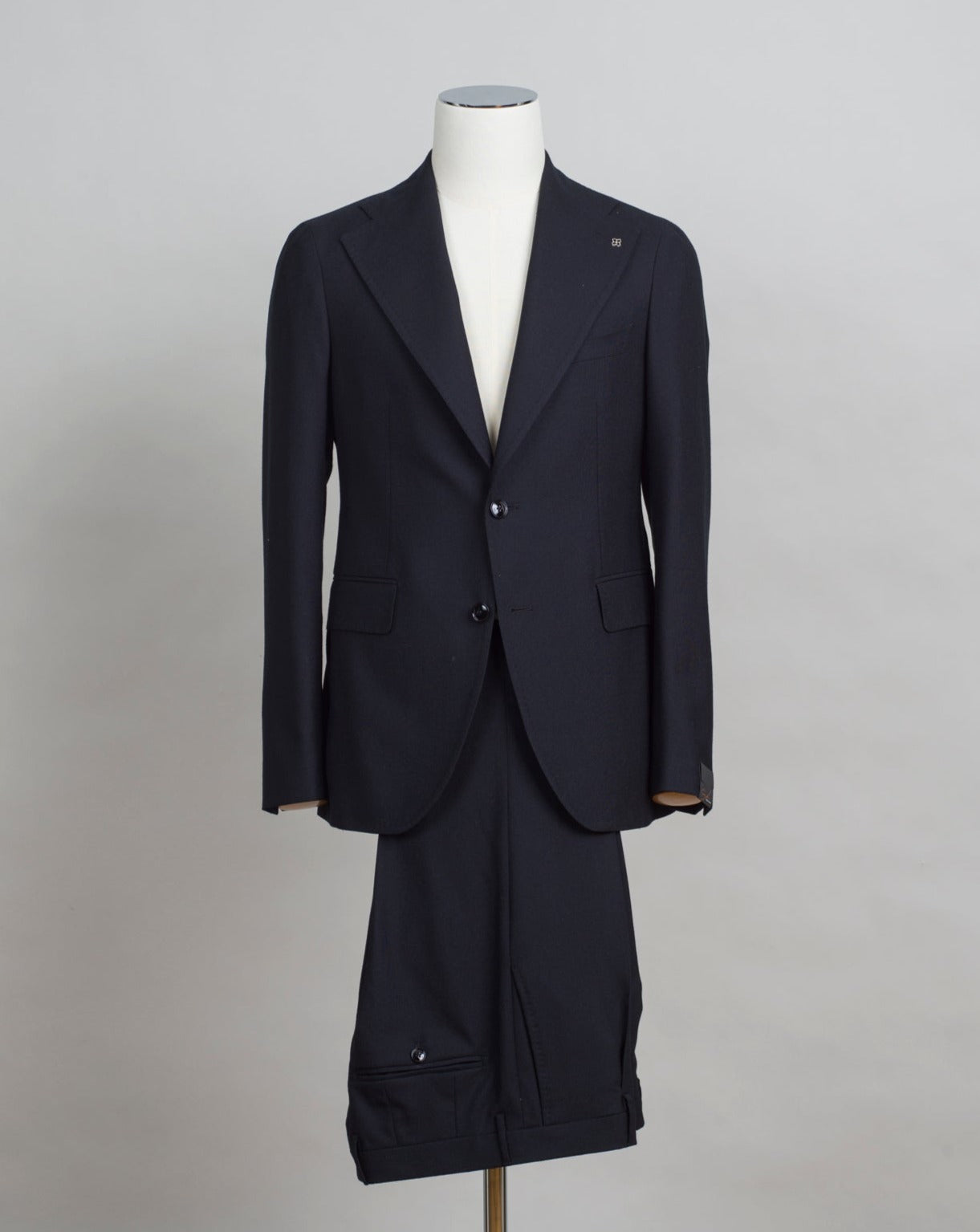 Slim fit. Take your normal suit size. If in doubt about your size, please contact us HERE 100% Wool Super 120´s Natural Stretch Unlined Unconstructed shoulder 2 buttons Side vents Notch lapel Flap pockets 1 pleat trousers Belt loops 1/2 bottom width 18 cm Composition: 100% Wool Color: Black Modello: A-PL22B11 Article: 06UIZ278 Colore: N5023 Made in Italy Black Tagliatore Pino Lerario suit. A black suit is a basic corner stone