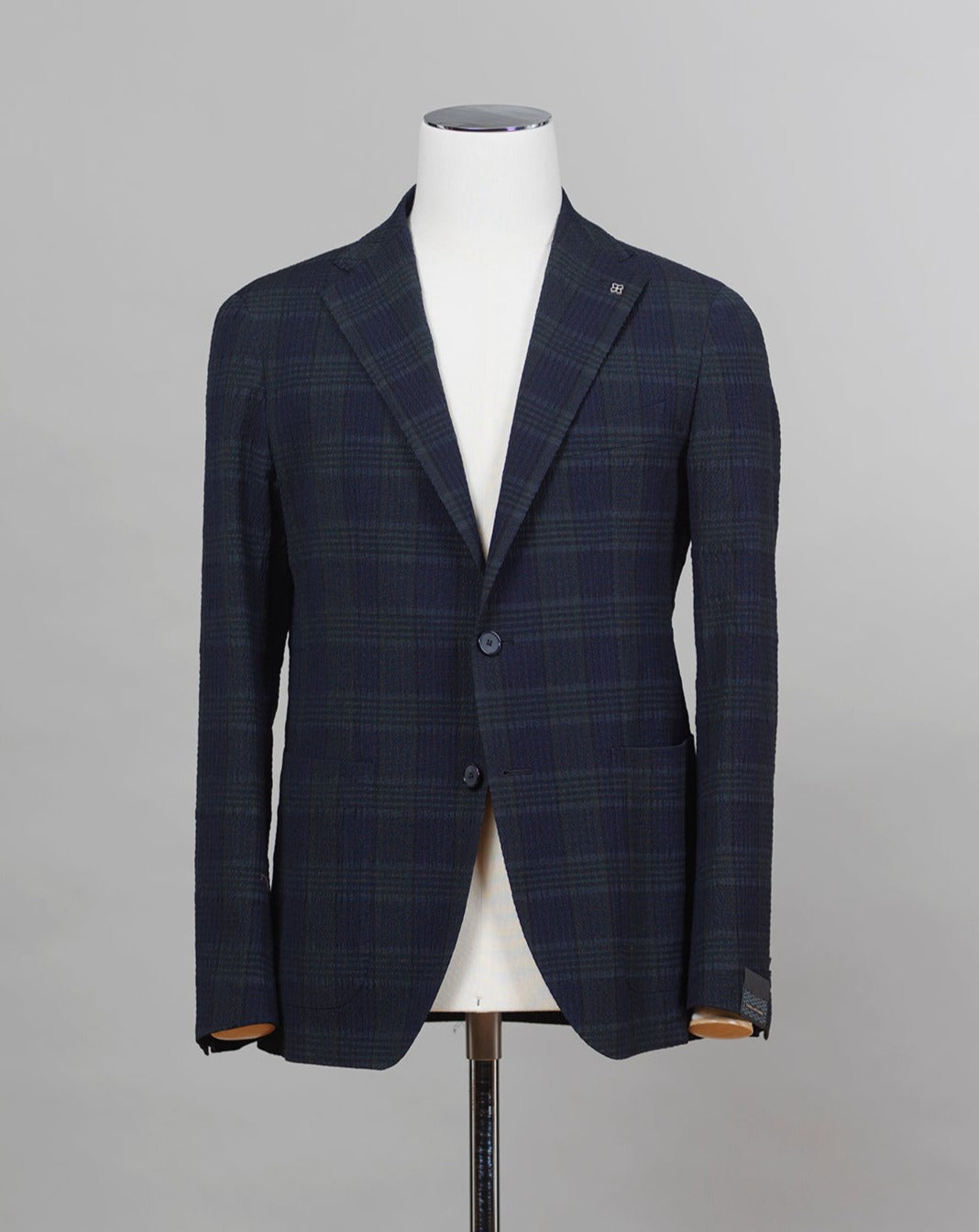 Tagliatore jacket made from a Black Watch seersucker fabric. The weave of seersucker fabric gives it a distinctive gentle wrinkled look. This come with a purpose. The wrinkles