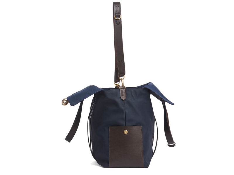 Measurements: L: 46 H: 34 W:18 cm Body: Waterproof hard woven Italian nylon Fabric Composition: PA 42% CO 38% PU 20% / 826g pr. meter Trimmings: Dark brown vegetable tanned full-grain bridle leather Lining: 100% cotton in Navy colour Hardware: Solid brass with varnish protection Zipper: Hand polished YKK Excella Art. No. MS111312 travel bag, or bend flaps down for a large, open city tote bag. A full-grain leather pocket on each gusset adds extra durability to the bottom corners
