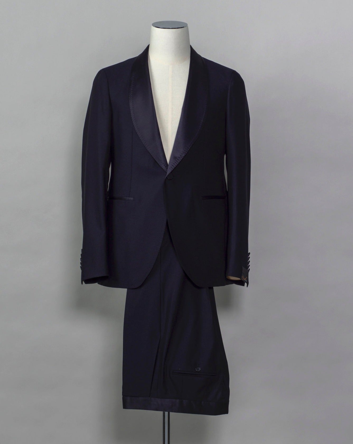 Tagliatore tuxedo with shawl collar. Unconstructed shoulder and half lined inside construction on jacket. Flat front trousers with satin waistband, matching to jacket lapel. Composition: 99% Virgin Wool Super 110's 1% Elastan Stretch Modello: S-PL18A01 LIS Color: Navy / B270 Unconstructed Unlined 1 button Shawl collar Jet pockets Back vent Flat front Made in Martina Franca, Italy