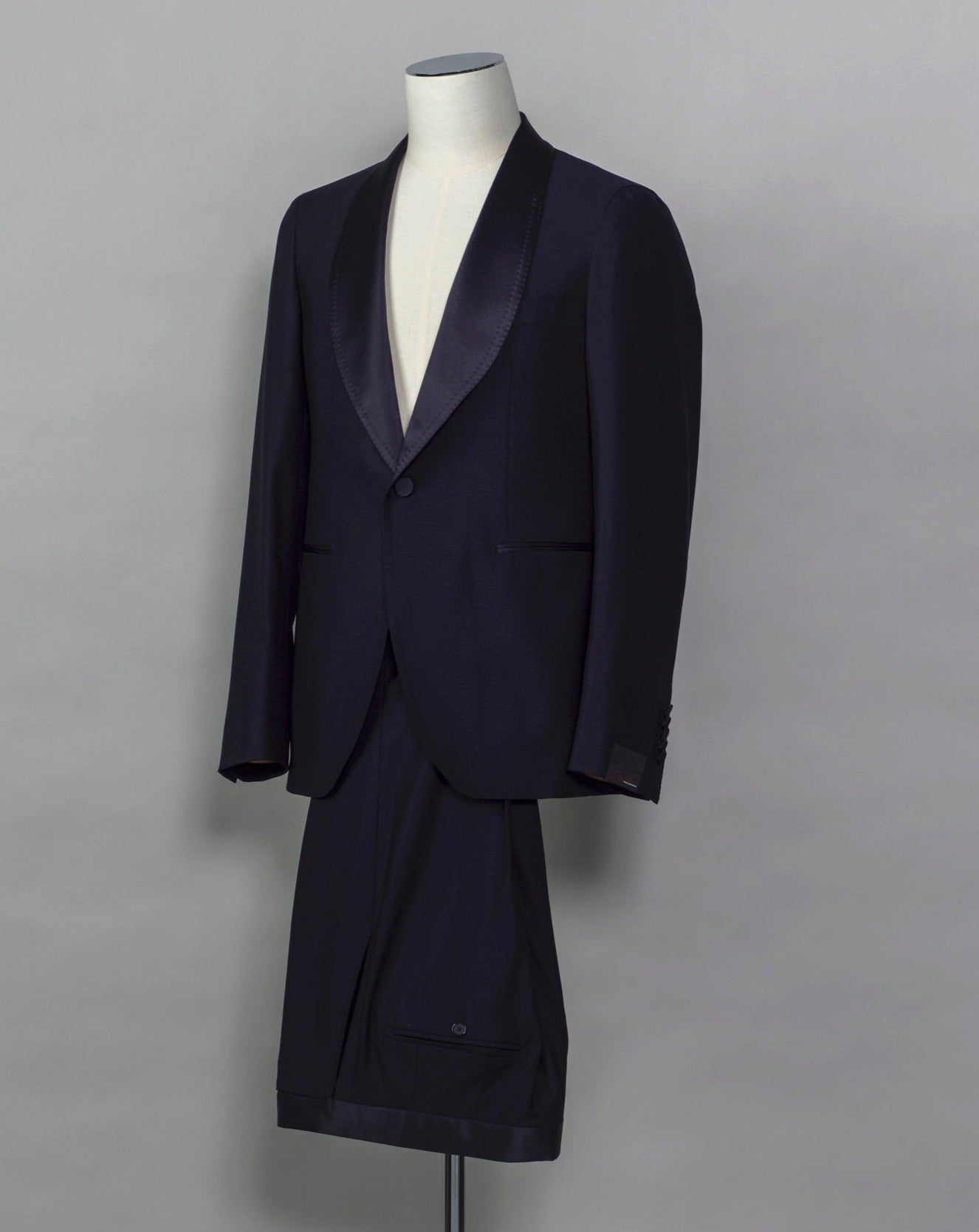 Tagliatore tuxedo with shawl collar. Unconstructed shoulder and half lined inside construction on jacket. Flat front trousers with satin waistband, matching to jacket lapel. Composition: 99% Virgin Wool Super 110's 1% Elastan Stretch Modello: S-PL18A01 LIS Color: Navy / B270 Unconstructed Unlined 1 button Shawl collar Jet pockets Back vent Flat front Made in Martina Franca, Italy